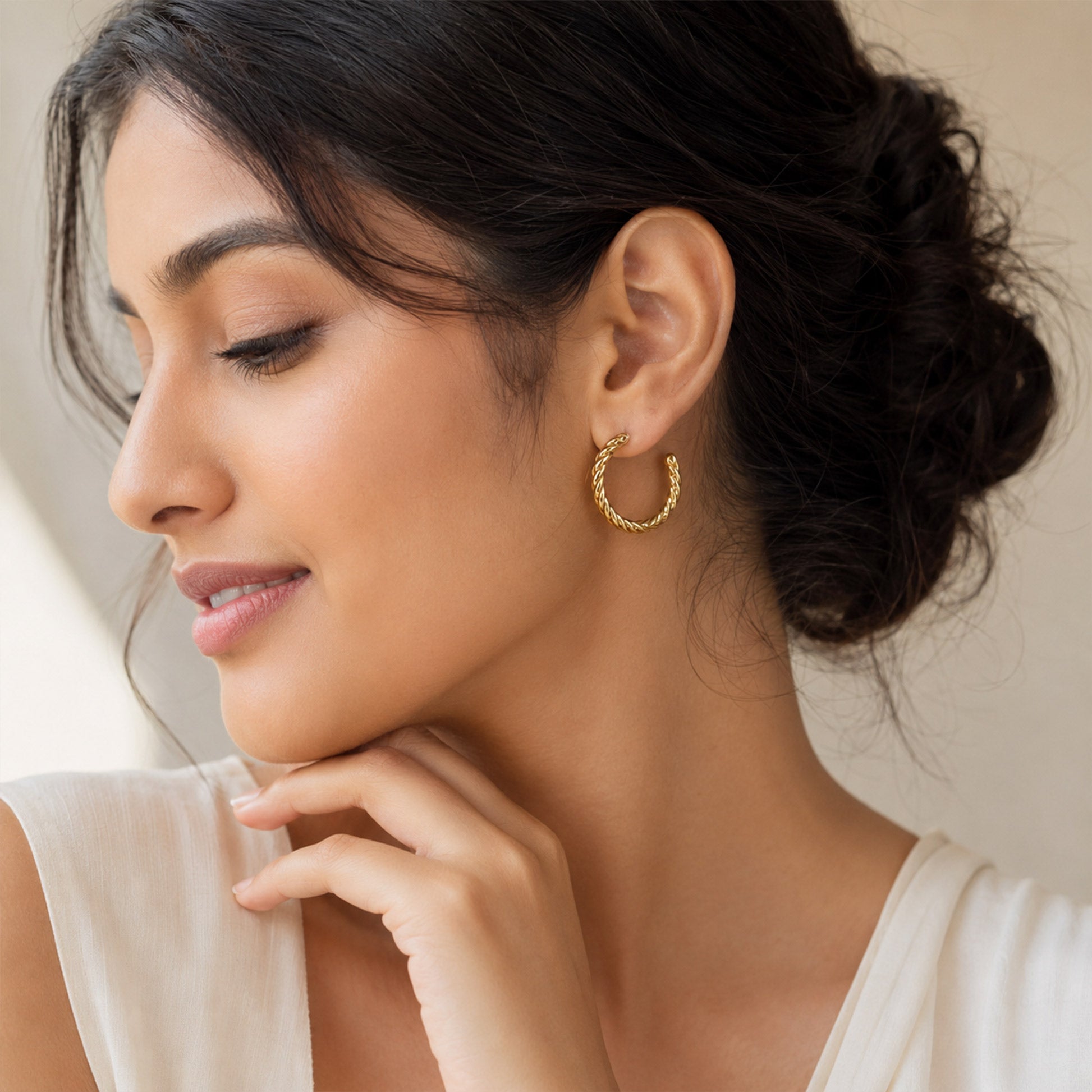 Close-up view of gold hoop earrings with rope texture