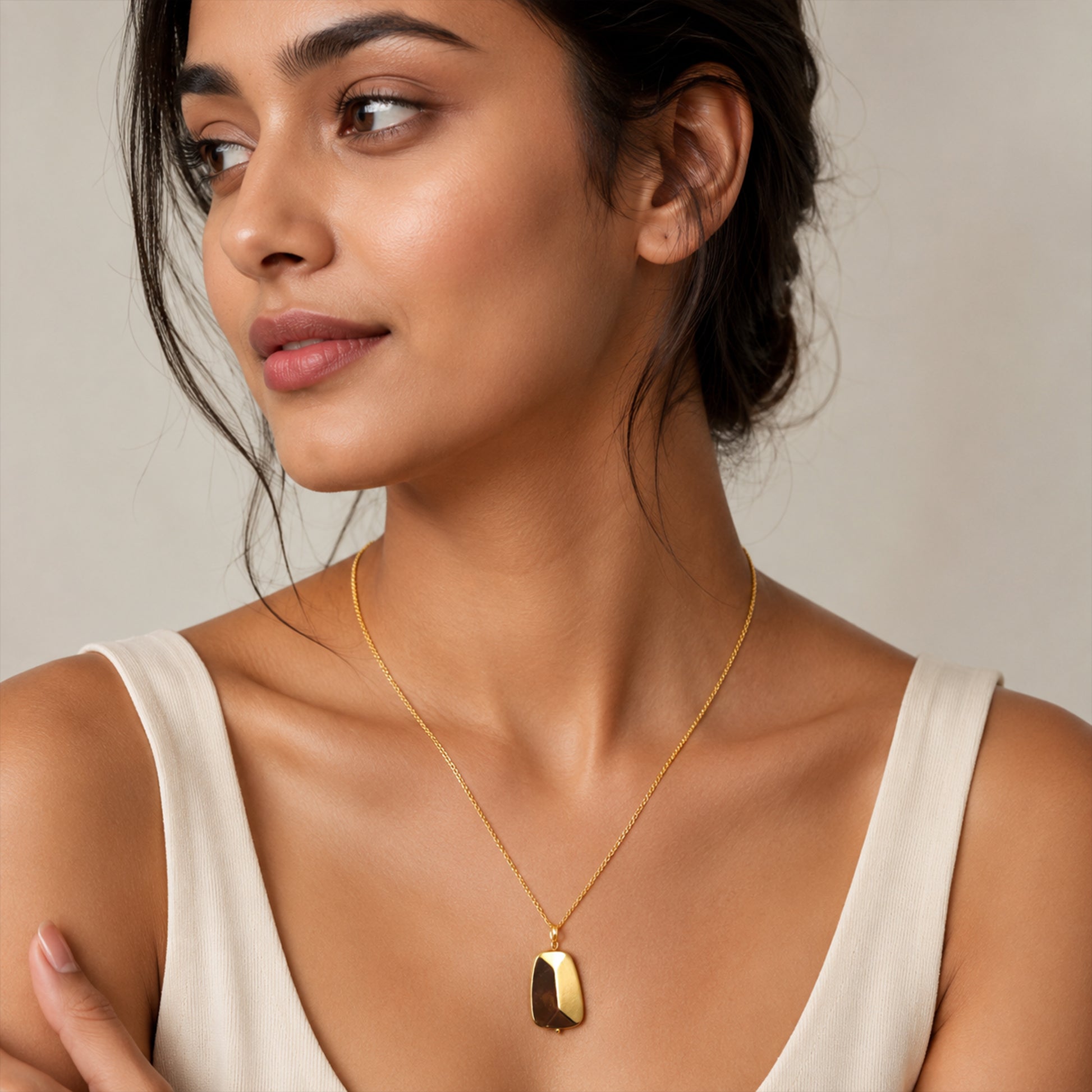 Close-up view of gold rectangular pendant necklace