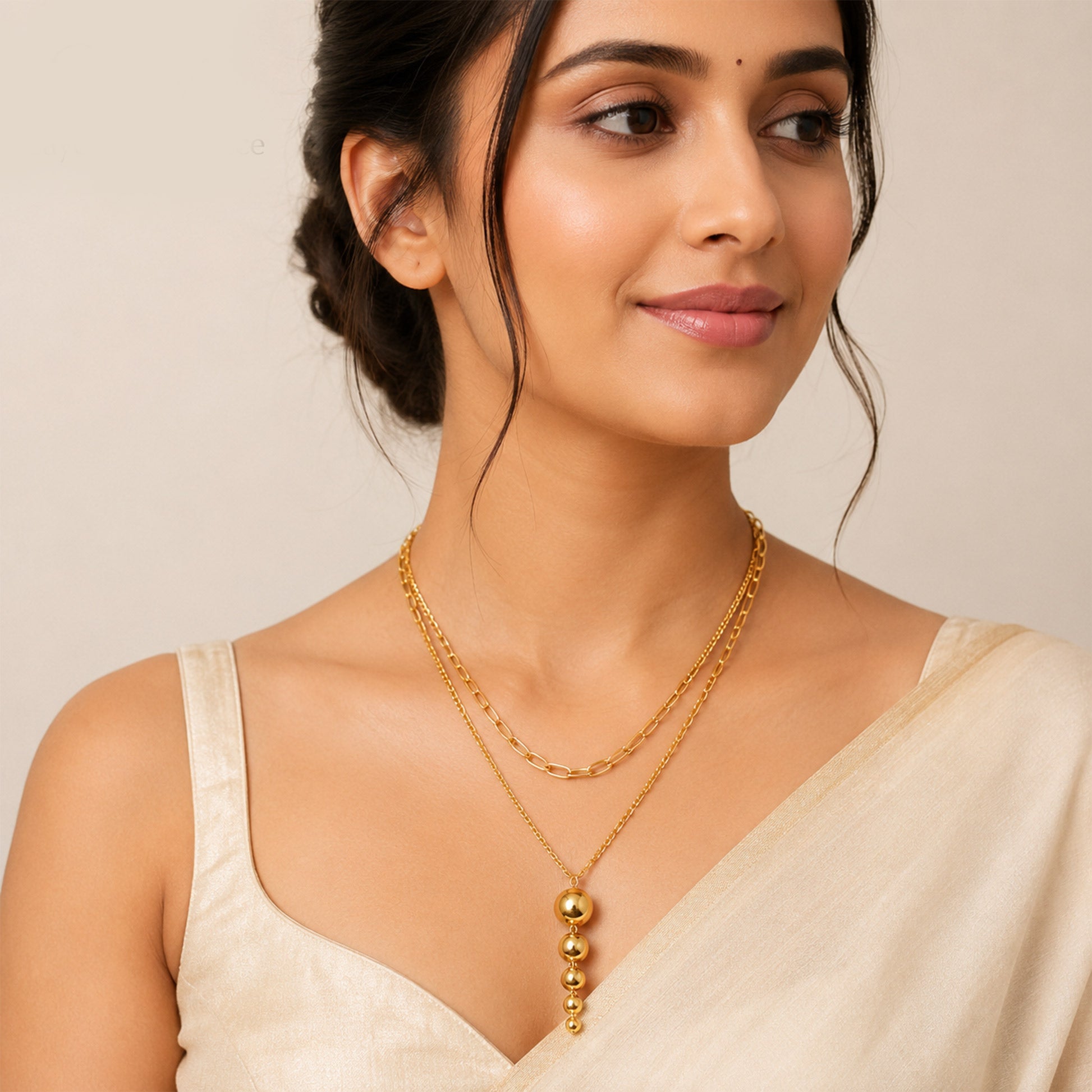 Close-up view of gold necklace with cascading polished bead design