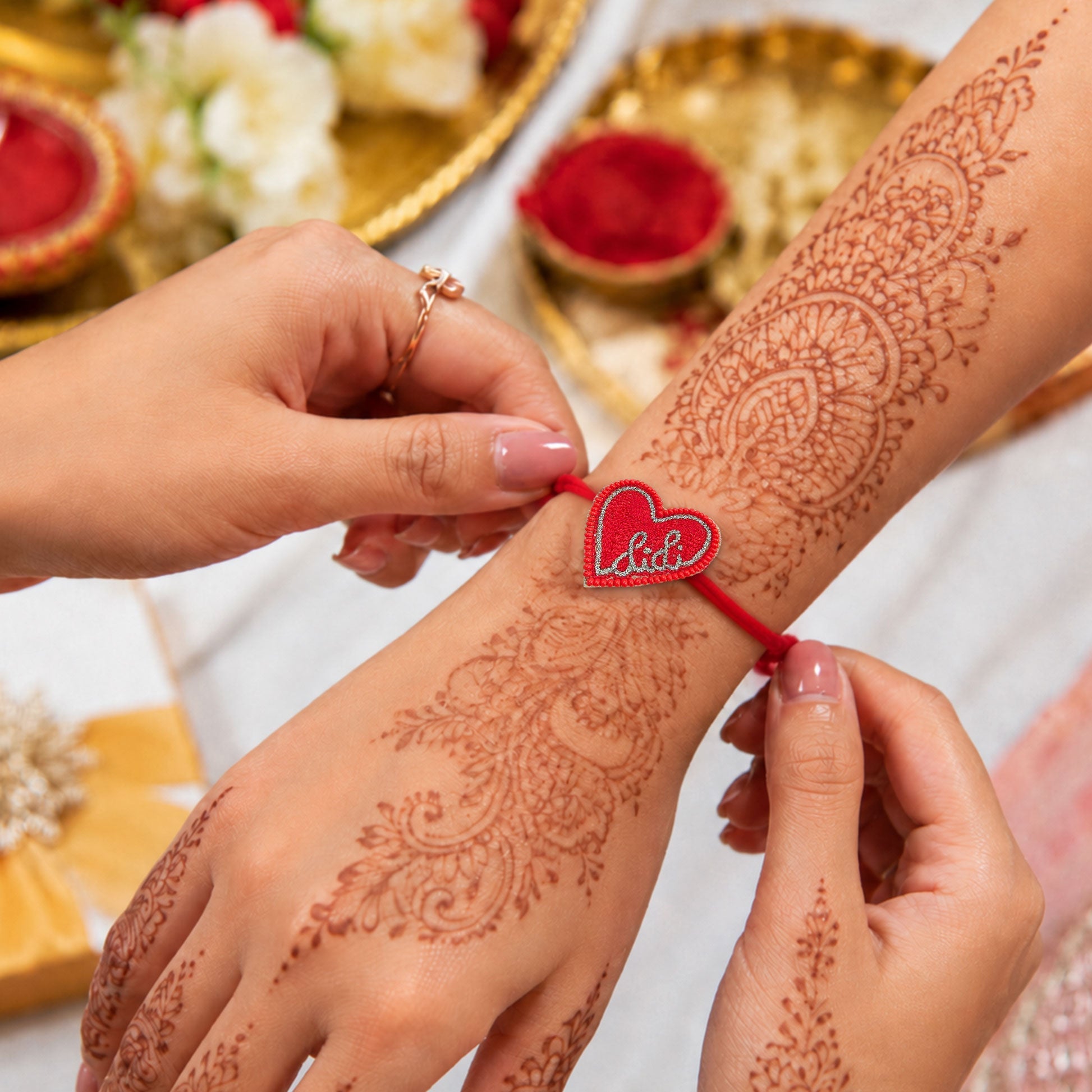 Red thread rakhi with Didi heart centerpiece