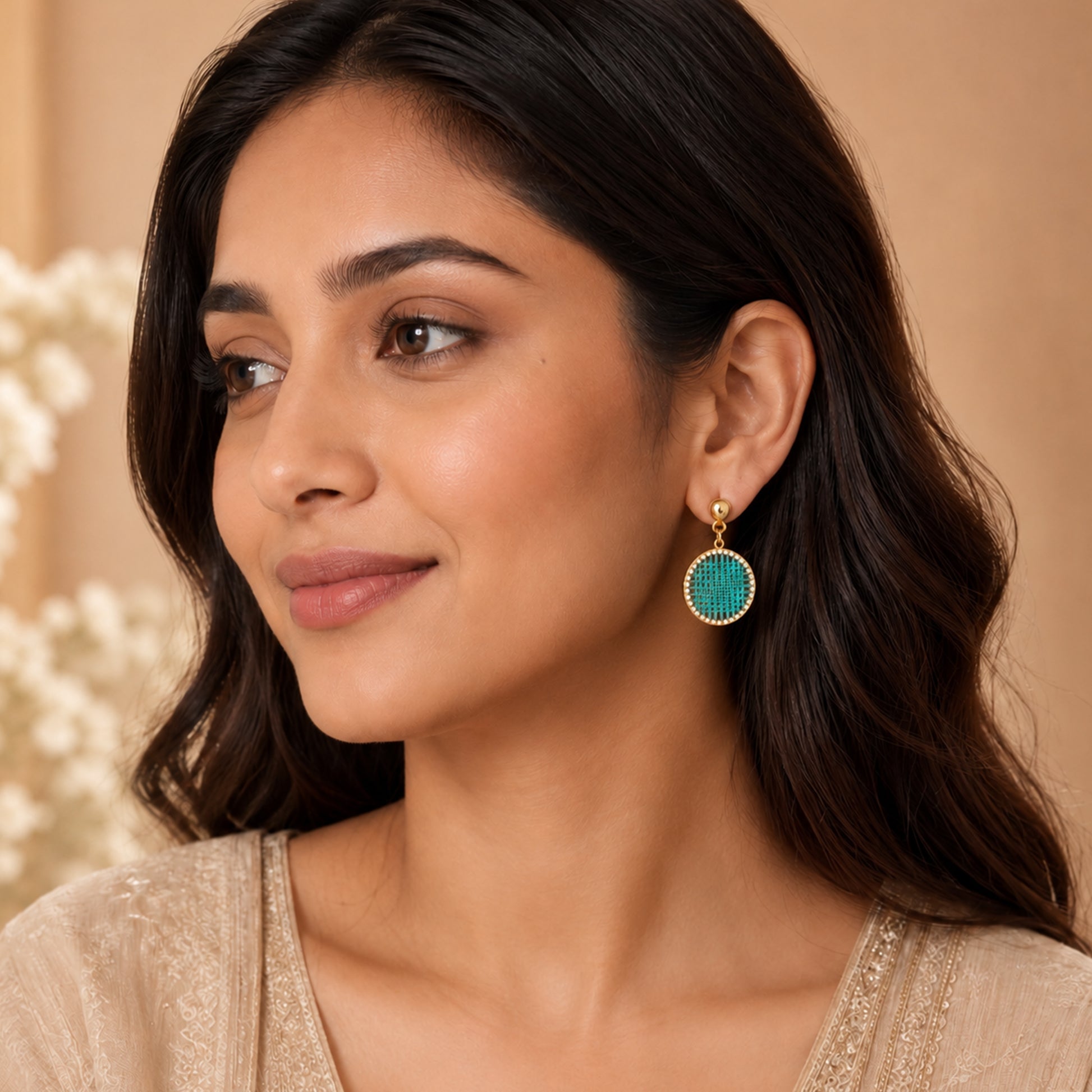 Close-up view of turquoise thread earrings with crystal border