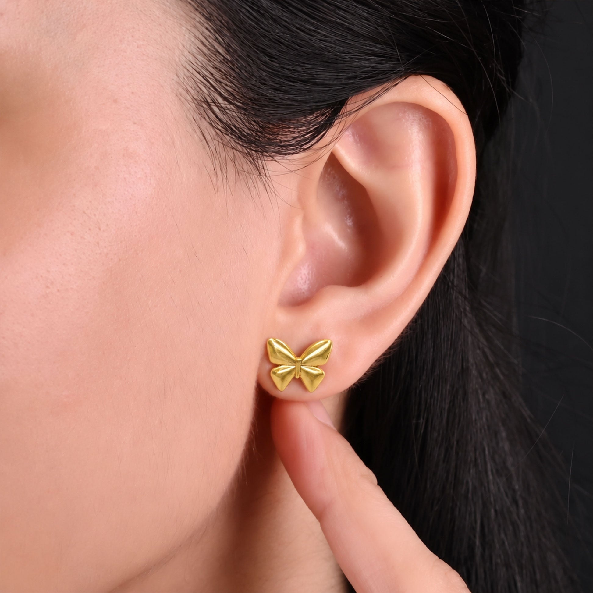 Close-up view of polished gold butterfly earrings