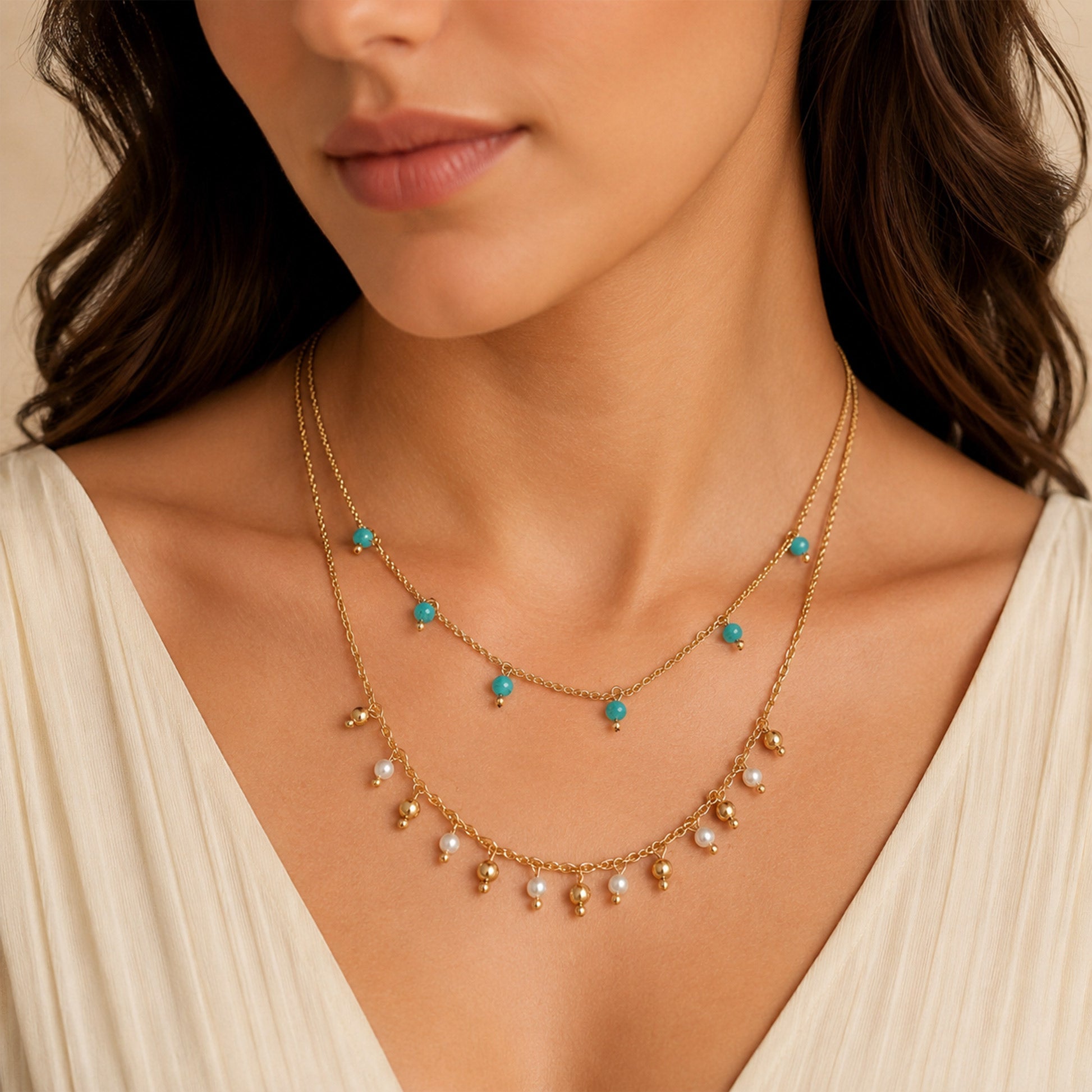 Close-up view of gold necklace with turquoise and pearl-style beads