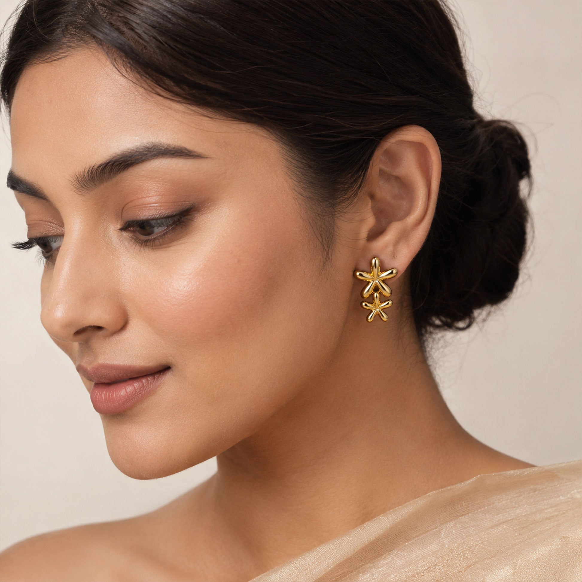 Close-up view of gold floral earrings with smooth rounded petals