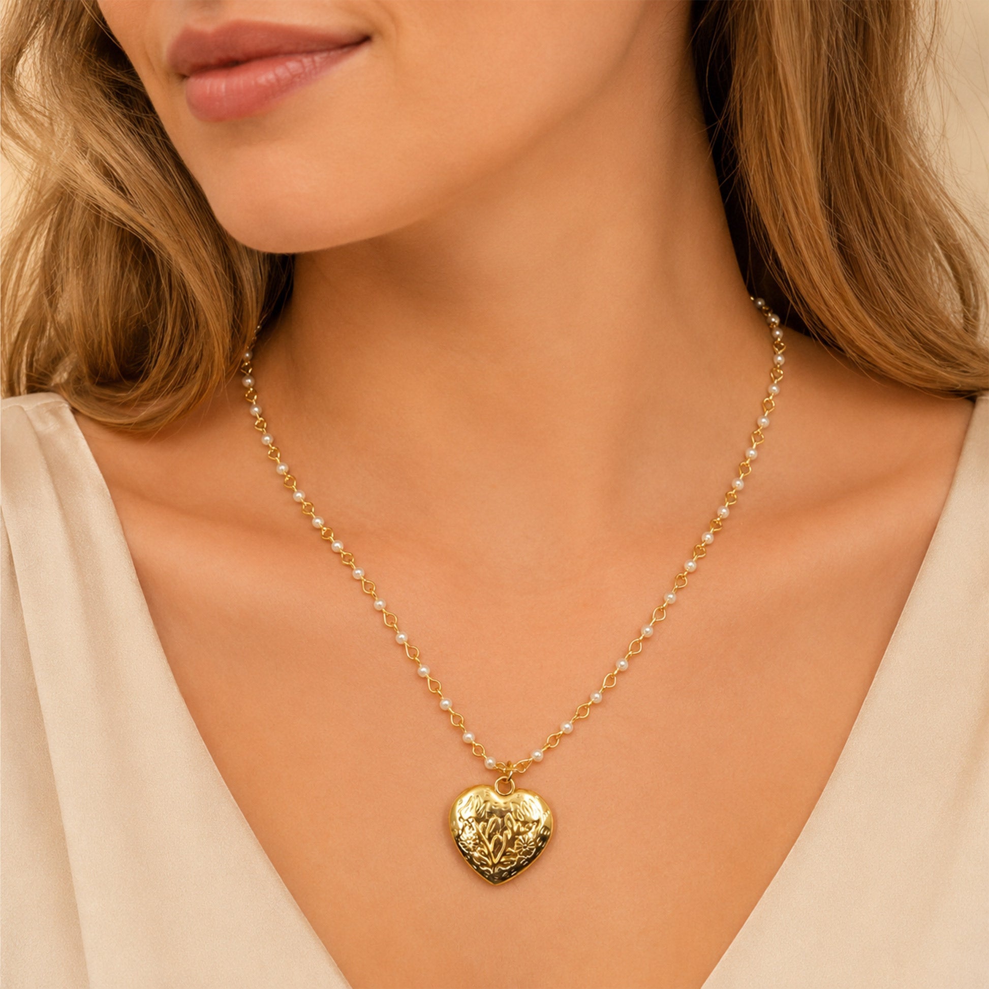 Close-up view of gold heart pendant with floral engraving