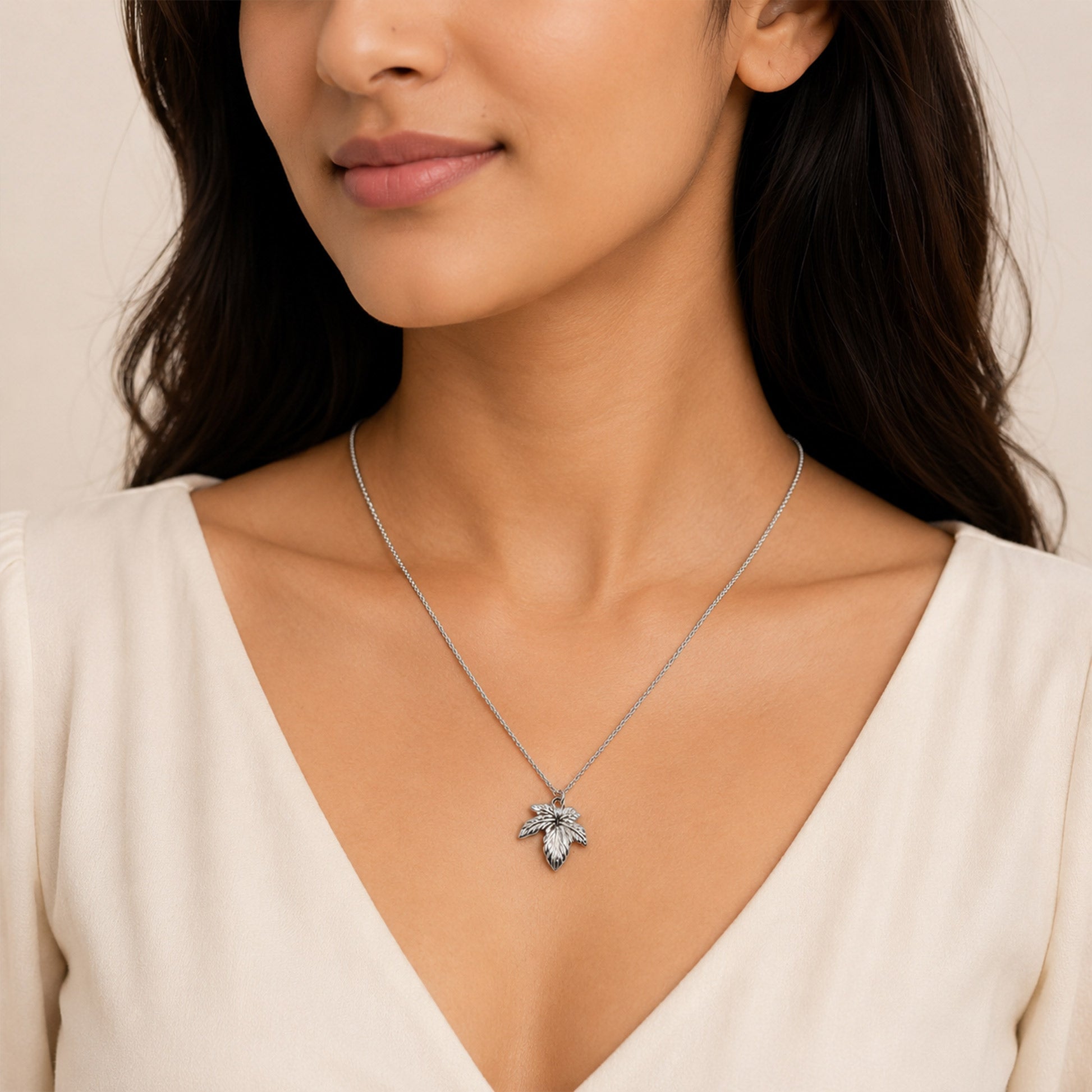 Close-up view of silver leaf necklace with engraved vein detailing