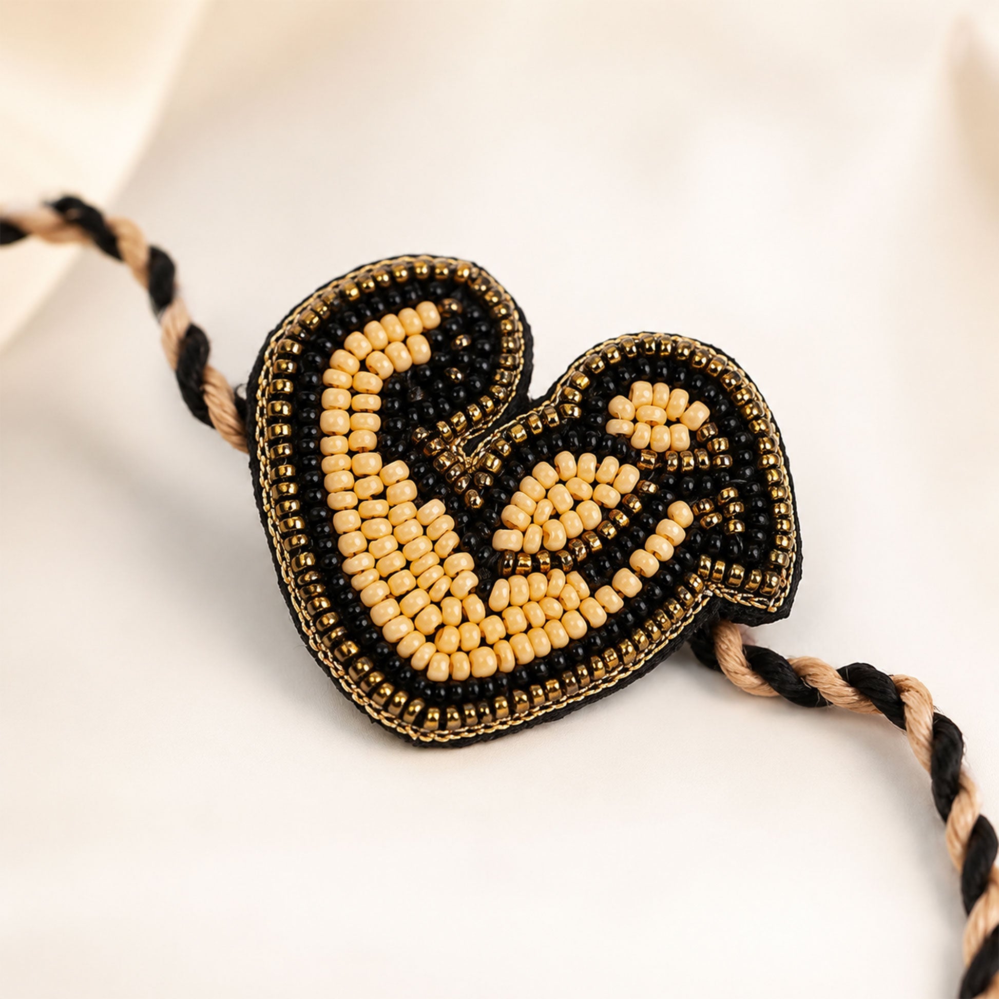 Black gold love beaded rakhi on festive background