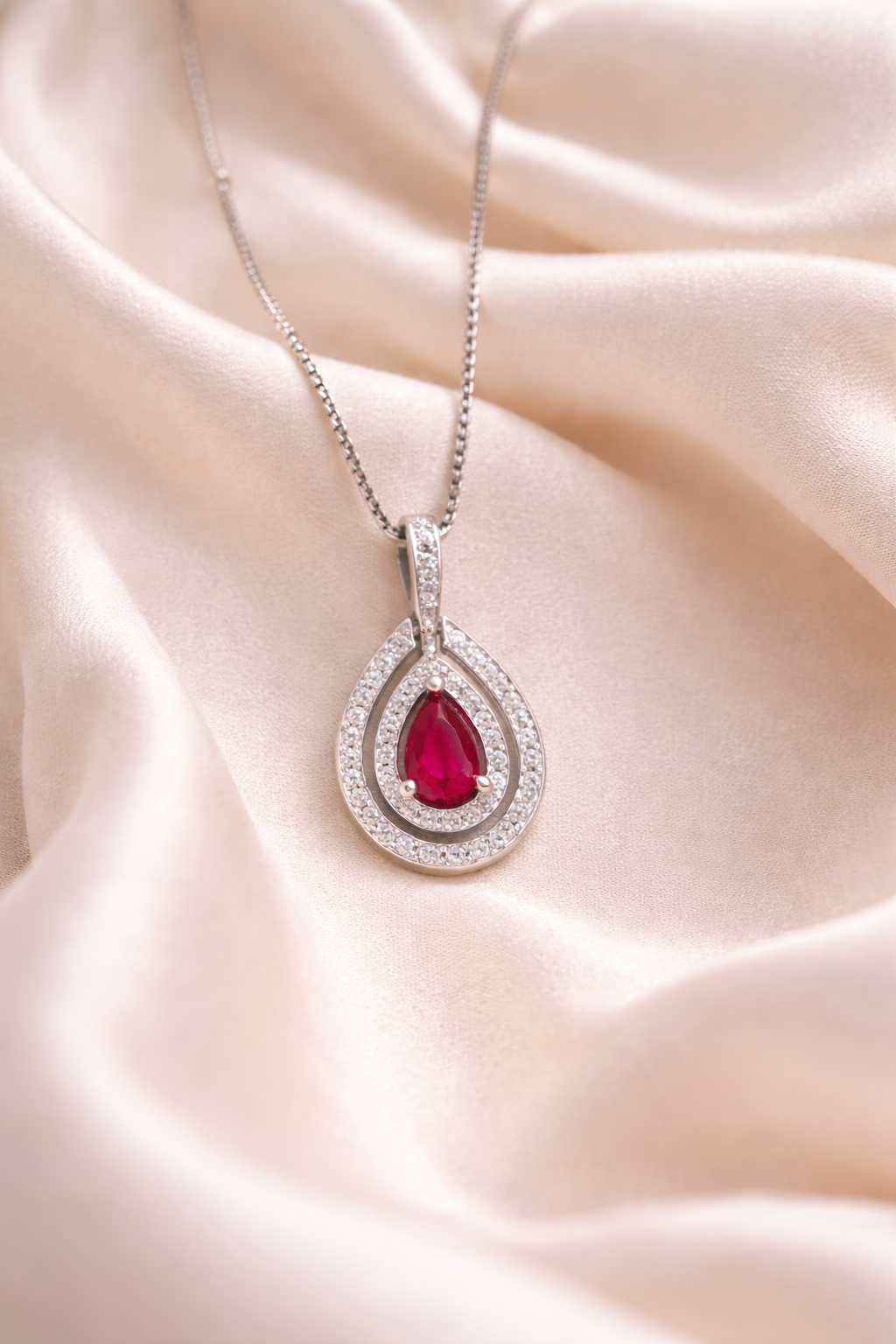 Elegant teardrop ruby pendant with sparkling CZ accents