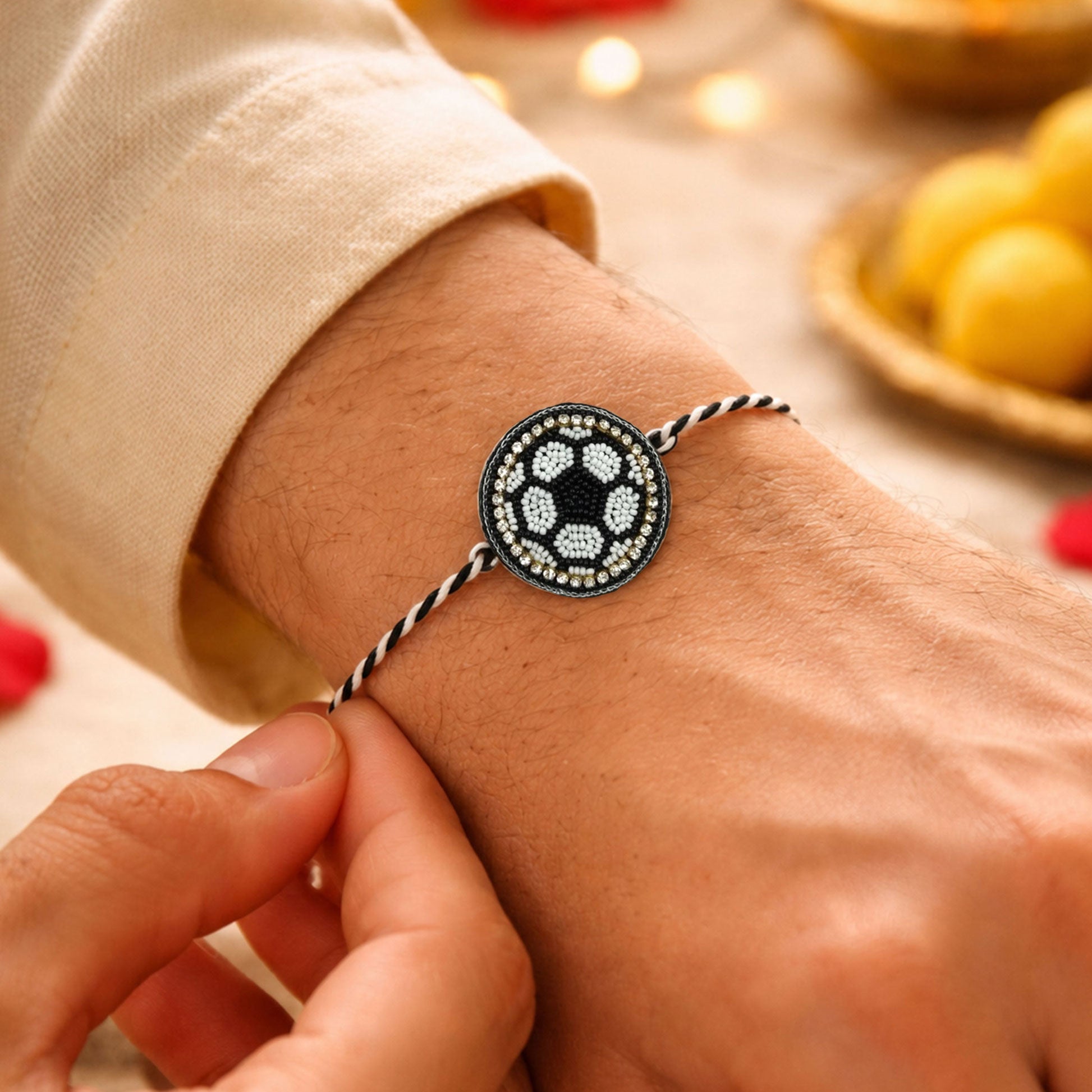 Black white braided thread rakhi with golden bead detailing