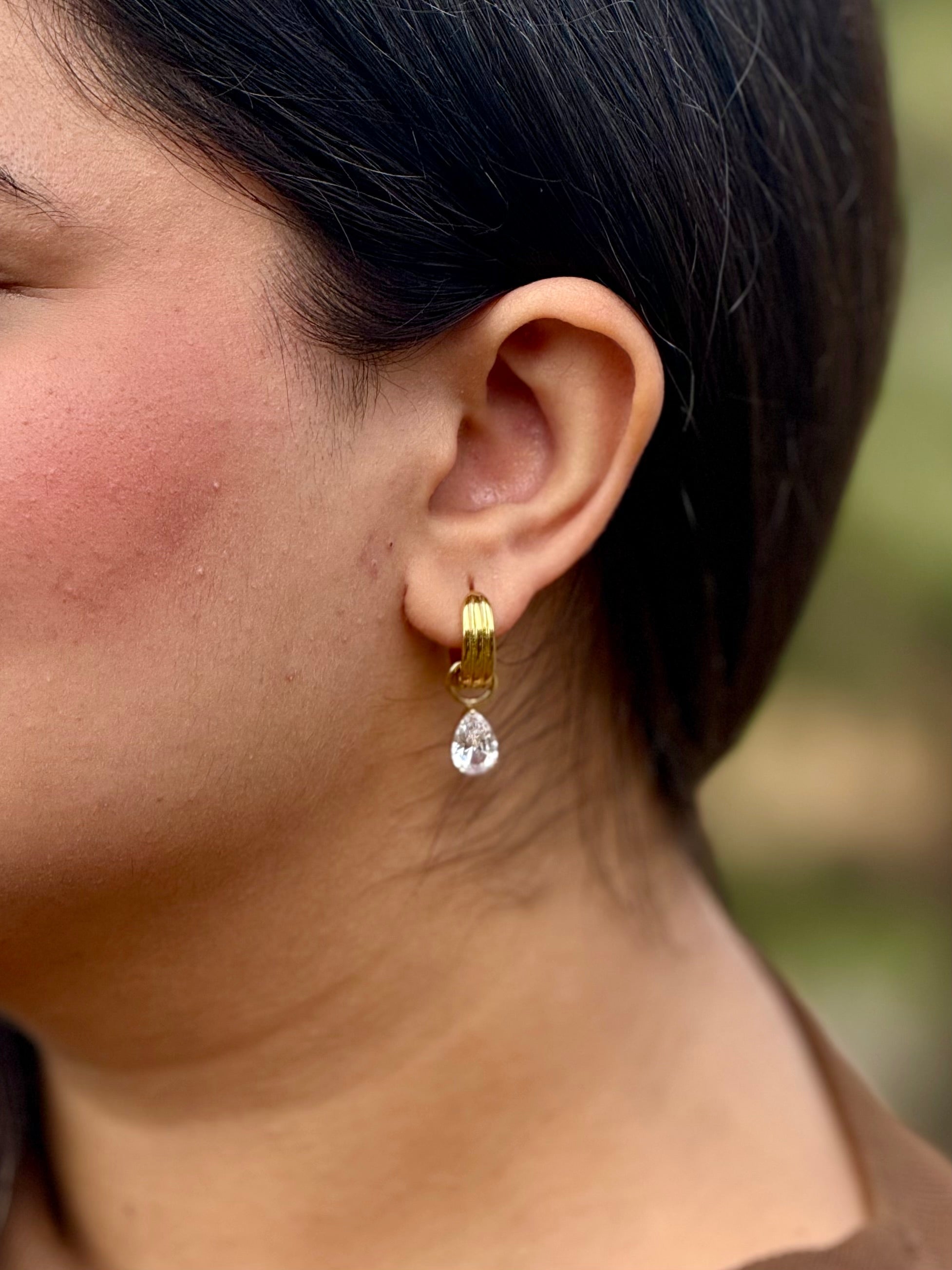 Pair of Noor huggies �? 18k gold-plated sparkle teardrop crystal huggies for everyday and gifting.