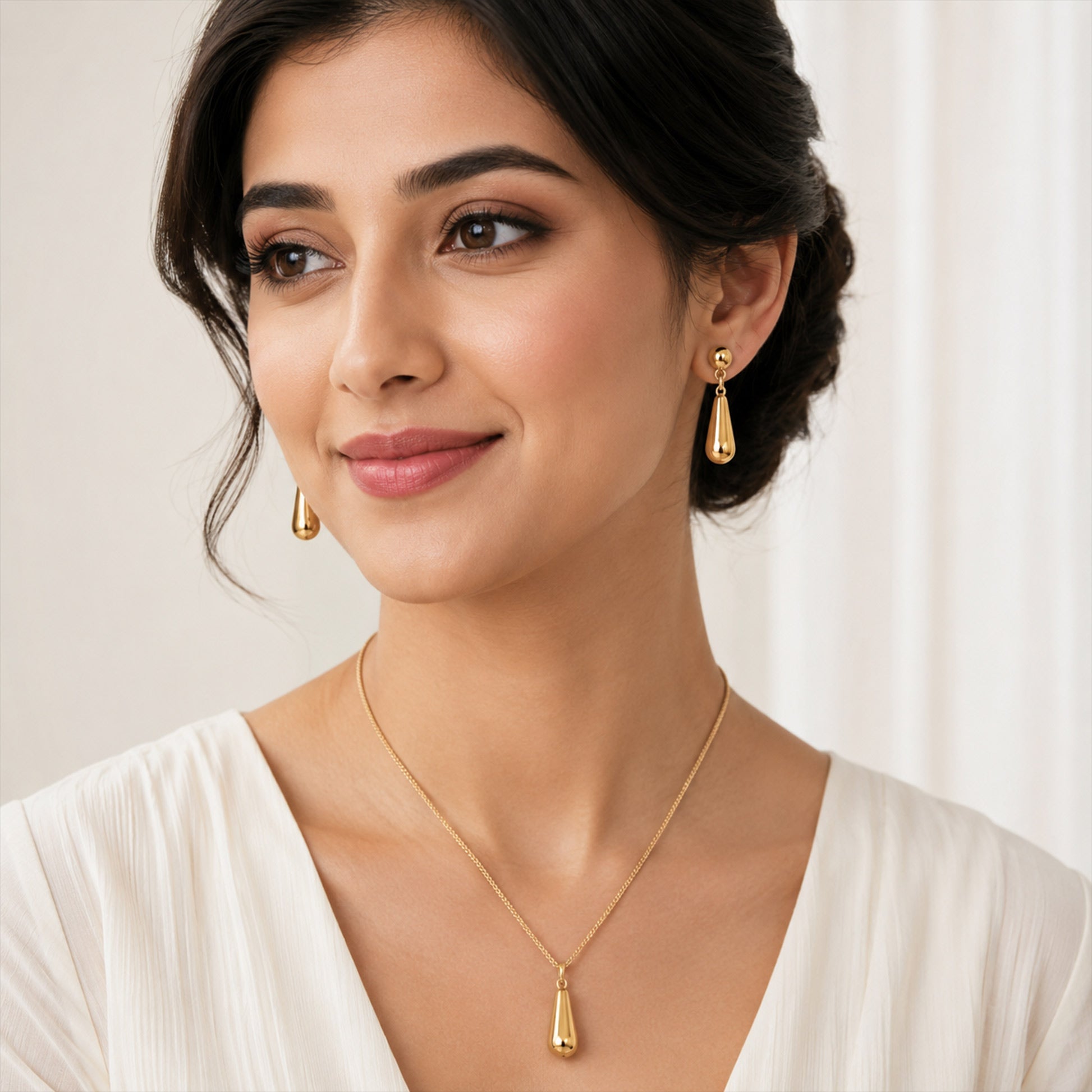 Close-up view of gold teardrop necklace with smooth finish