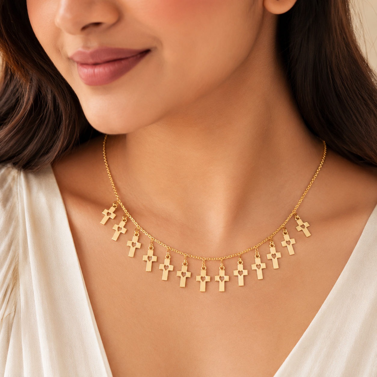 Close-up view of gold necklace with cross and heart charms