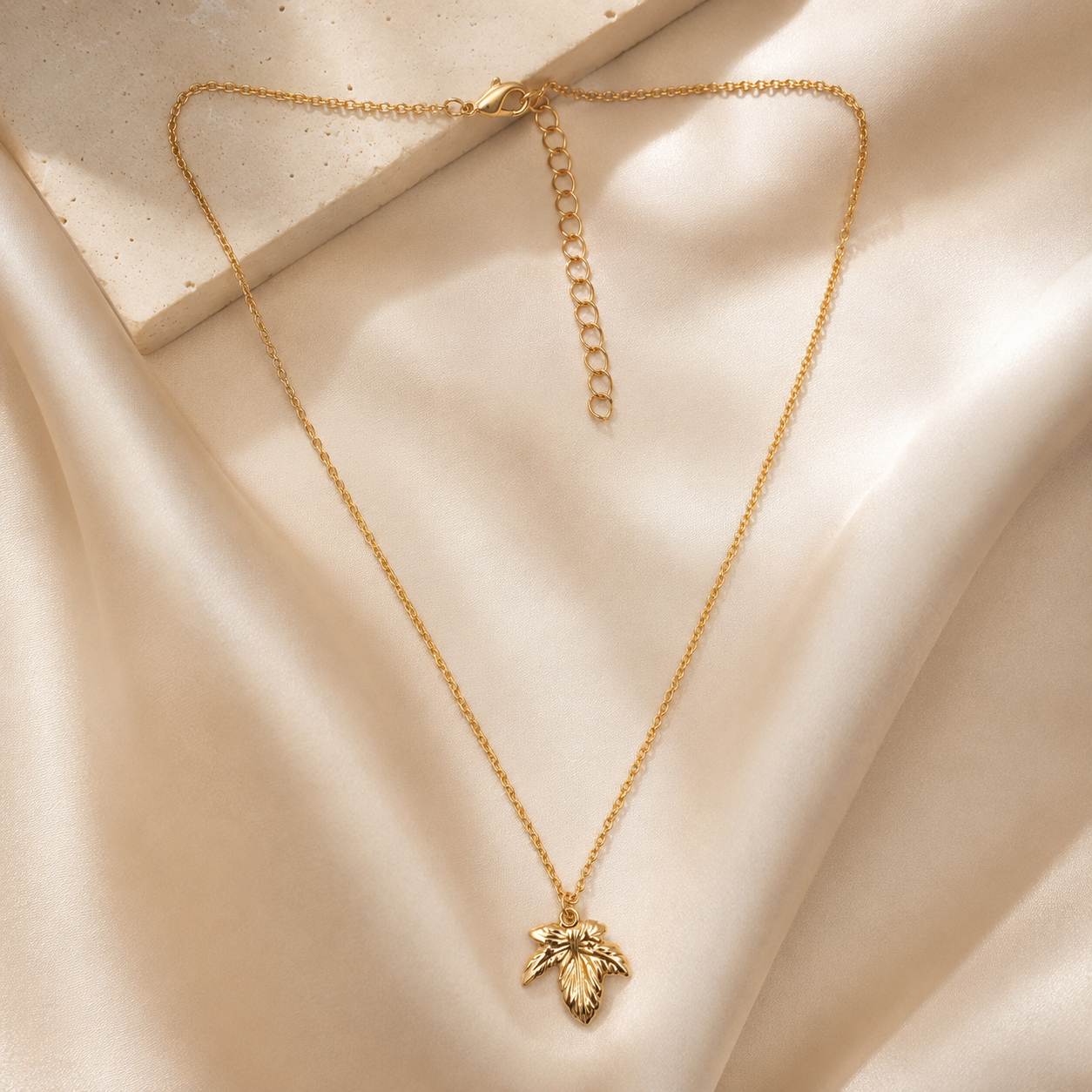 Close-up view of gold leaf necklace with engraved detailing