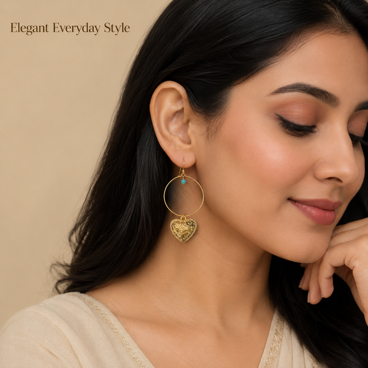 Close-up view of gold hoop earrings with engraved heart charm