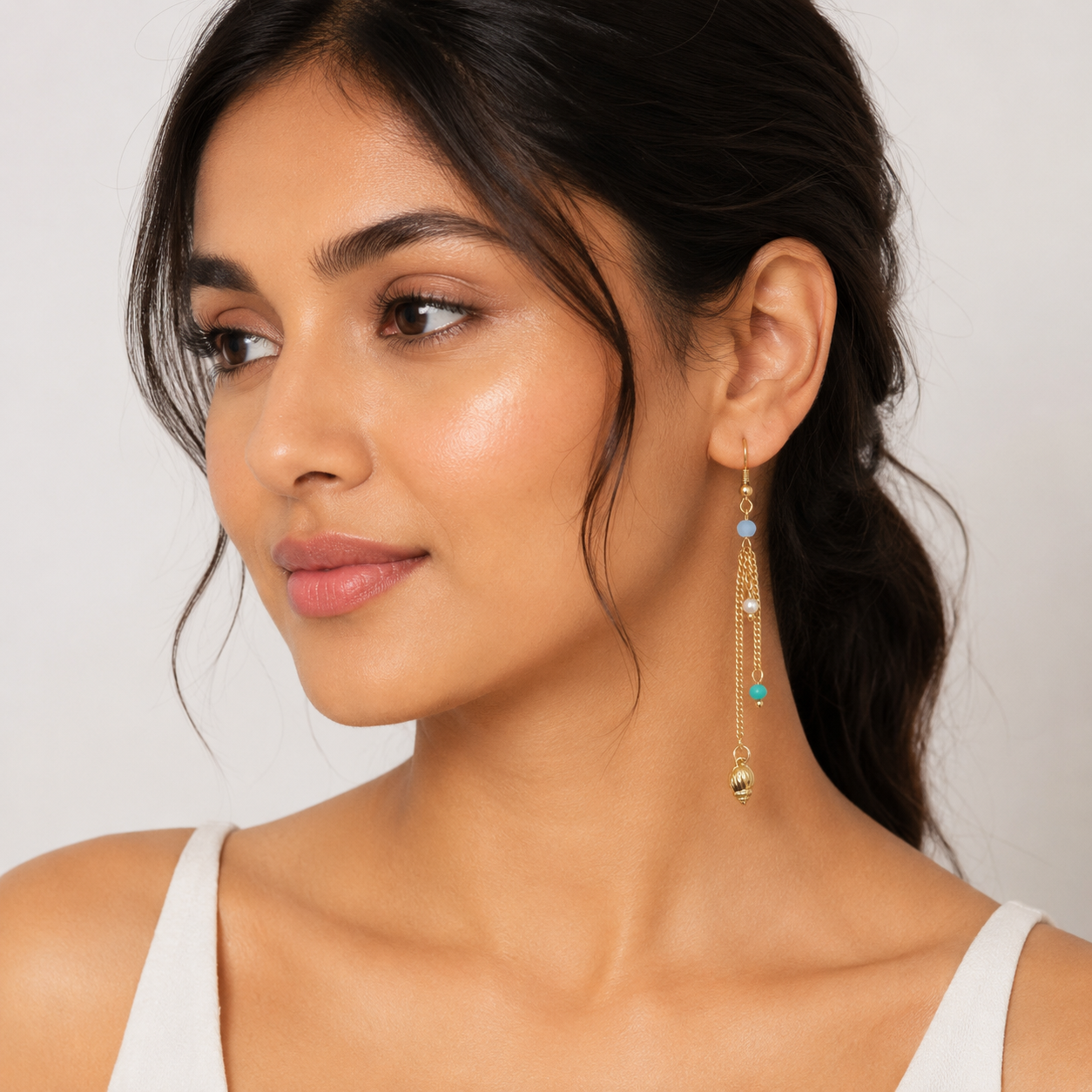 Close-up view of gold chain tassel earrings with blue beads