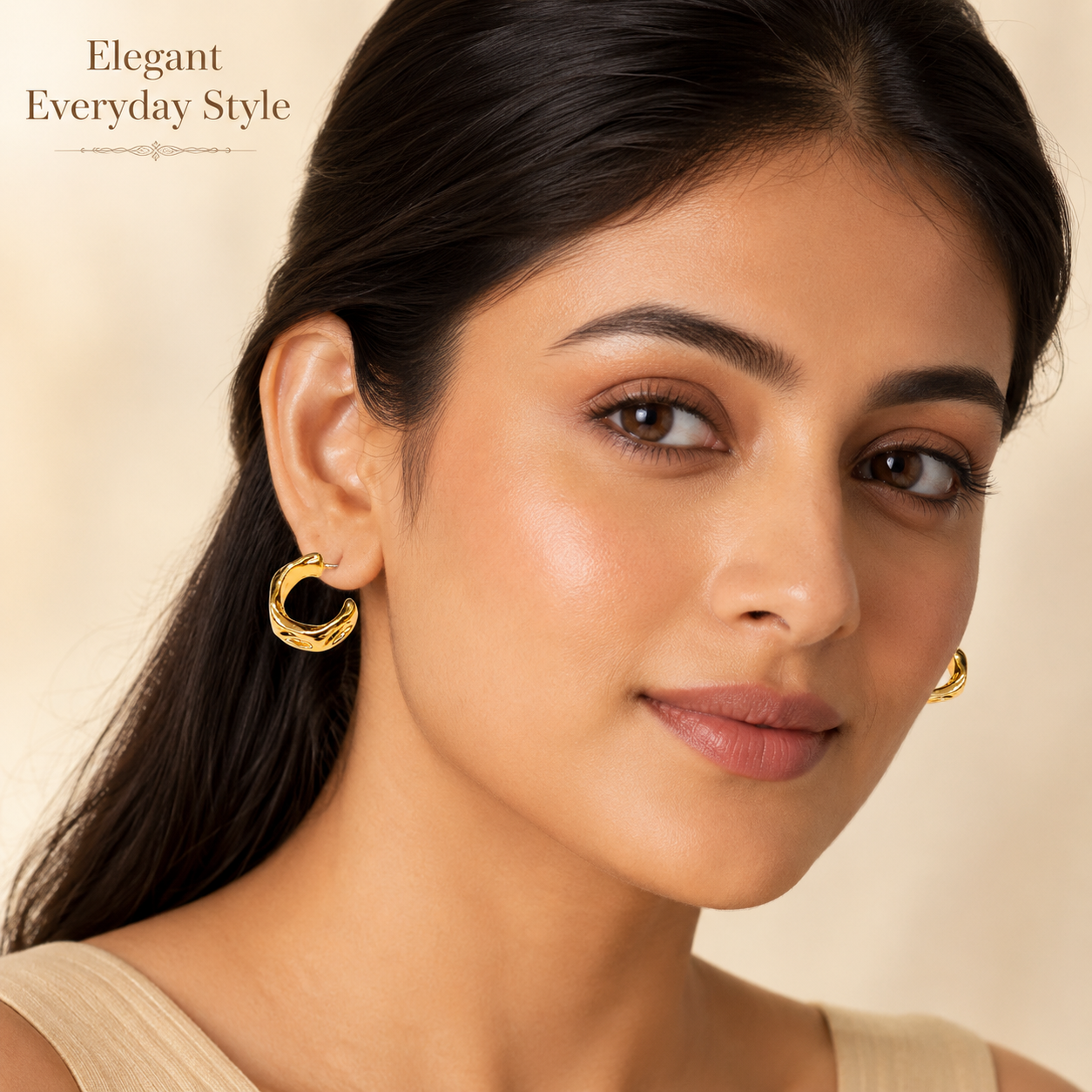 Close-up view of gold hoop earrings with curved wave detailing