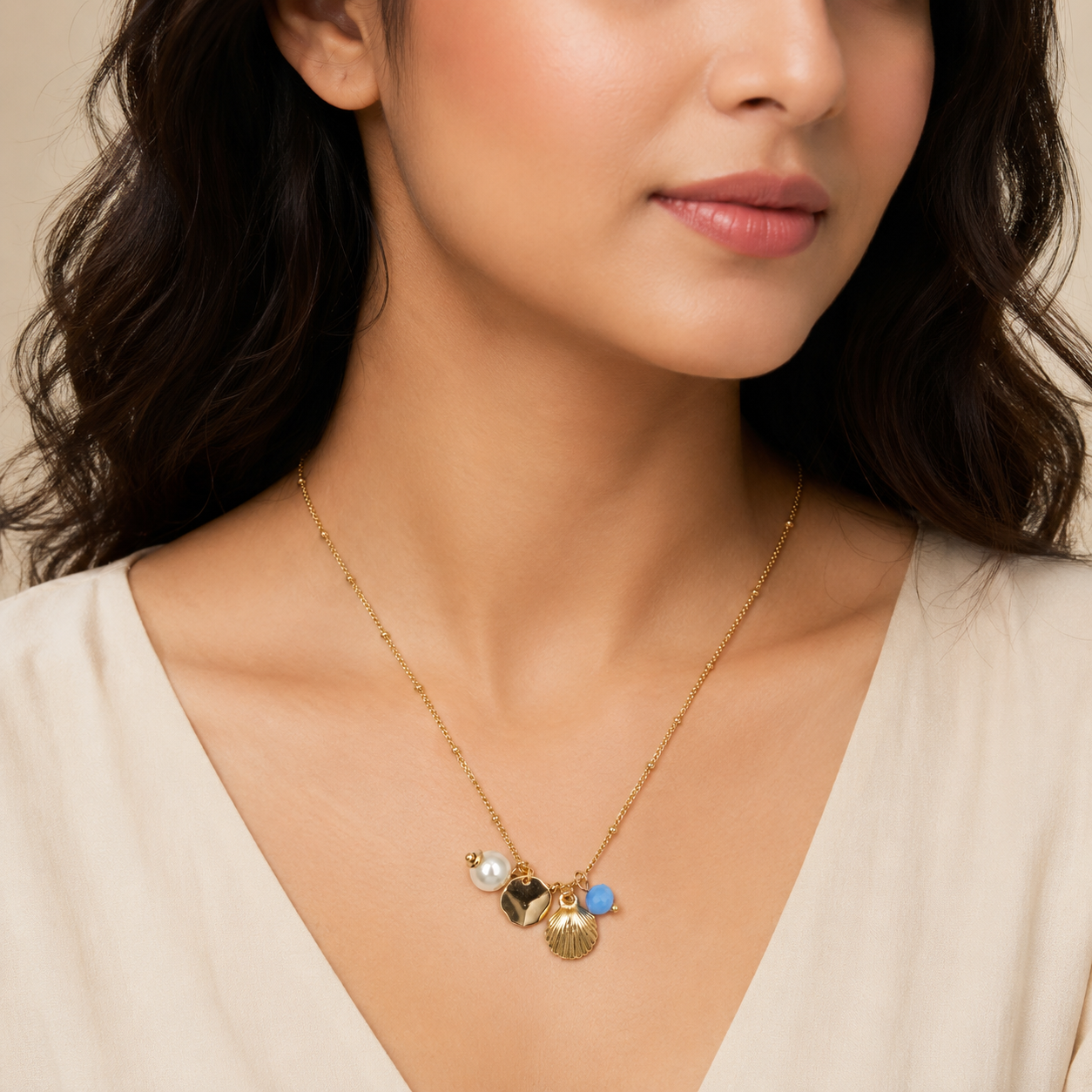 Close-up view of gold necklace with seashell and pearl charm