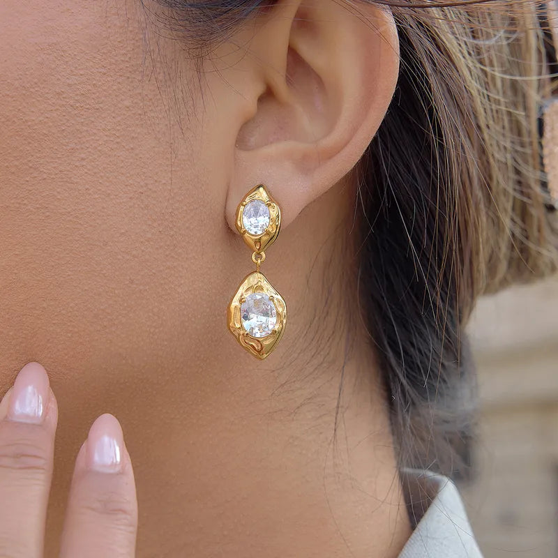 Close-up of gold stone drop earrings �? eye-catching stone-set drops in 18k gold-plated stainless steel.