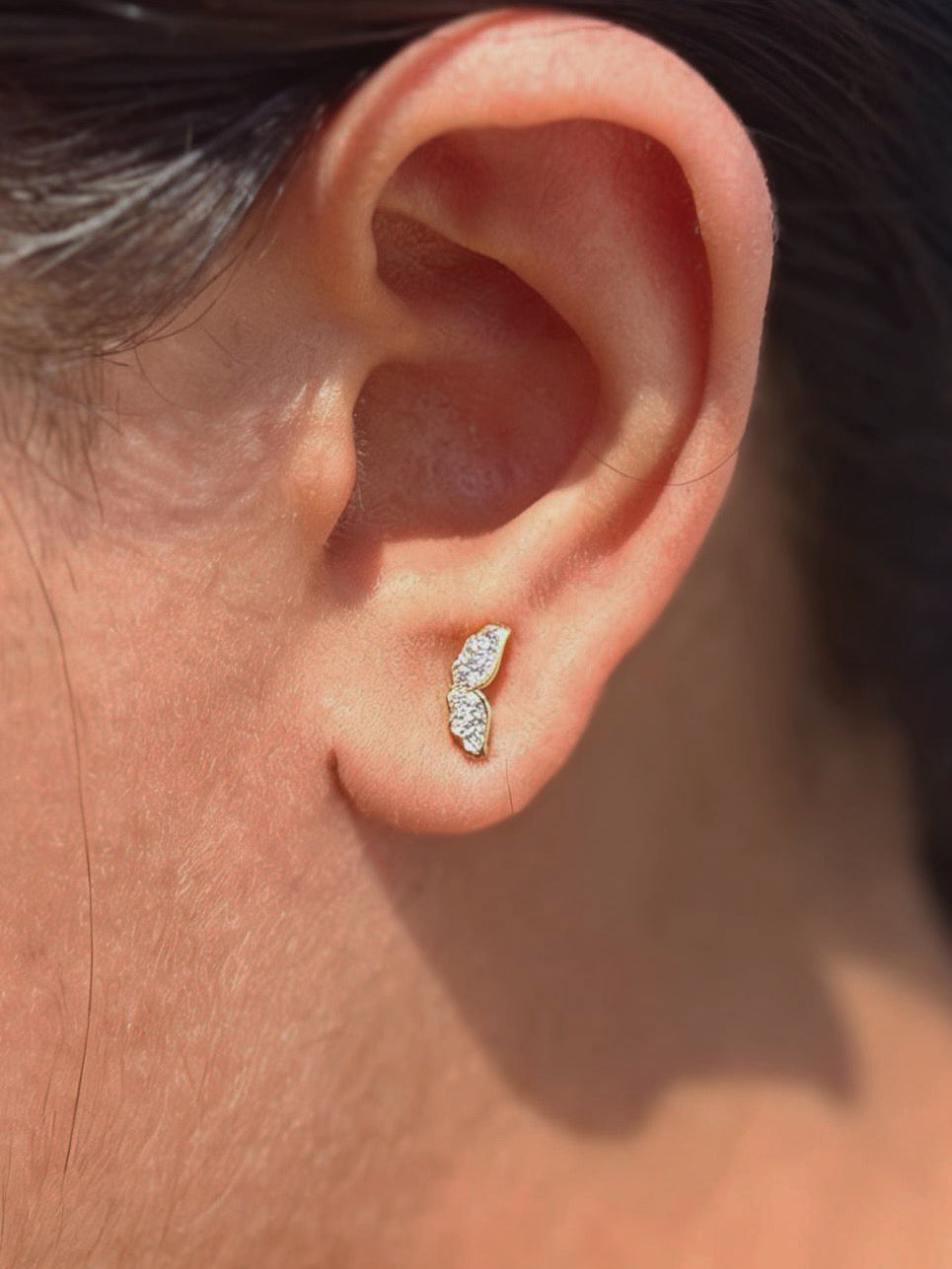 Detail shot of wing ball-back stud earrings �? 18k gold-plated wing studs for everyday and gifting.