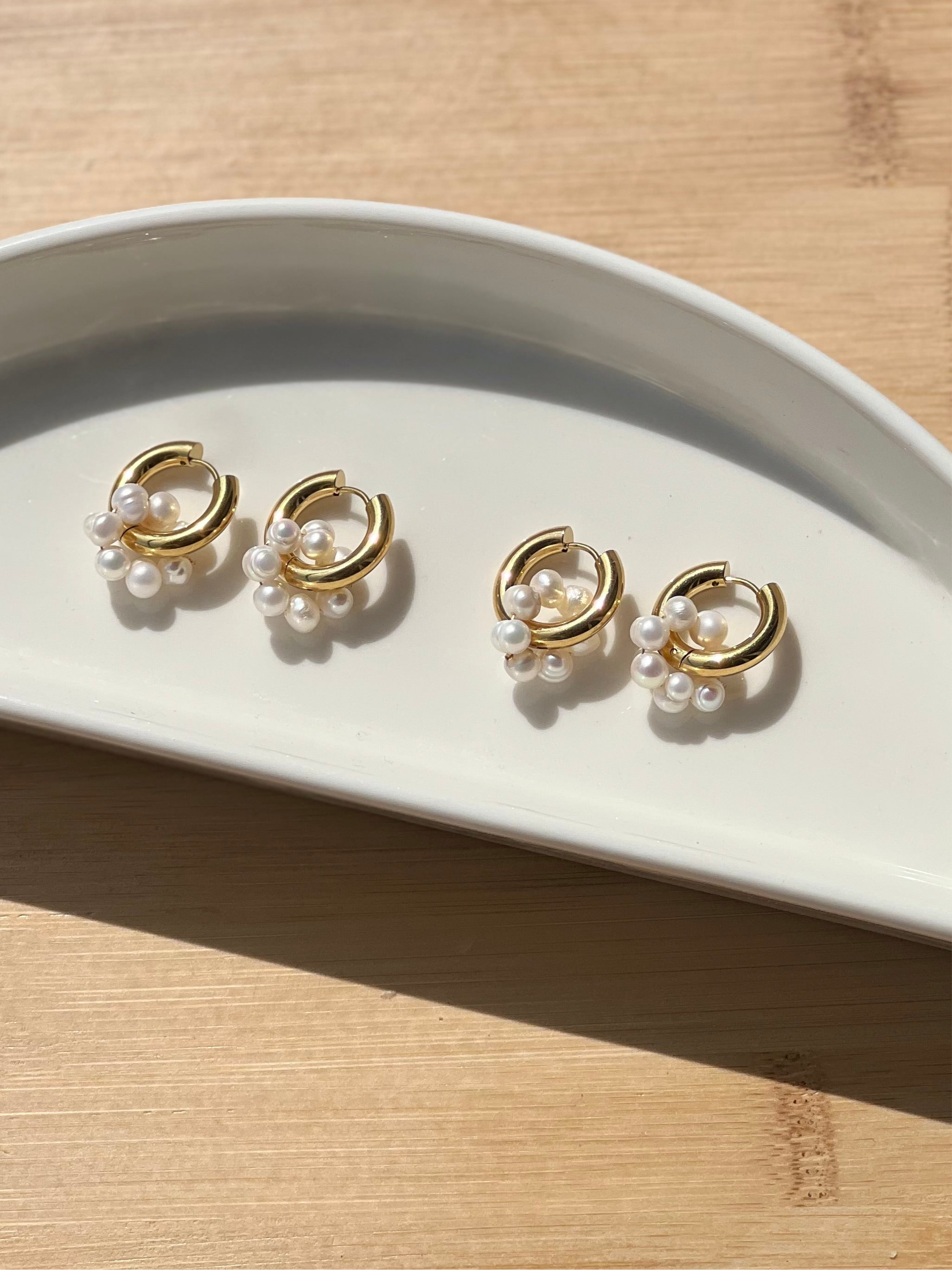 Alina pearl drops shown styled flat �? 18k gold-plated freshwater pearl drops for everyday and gifting.