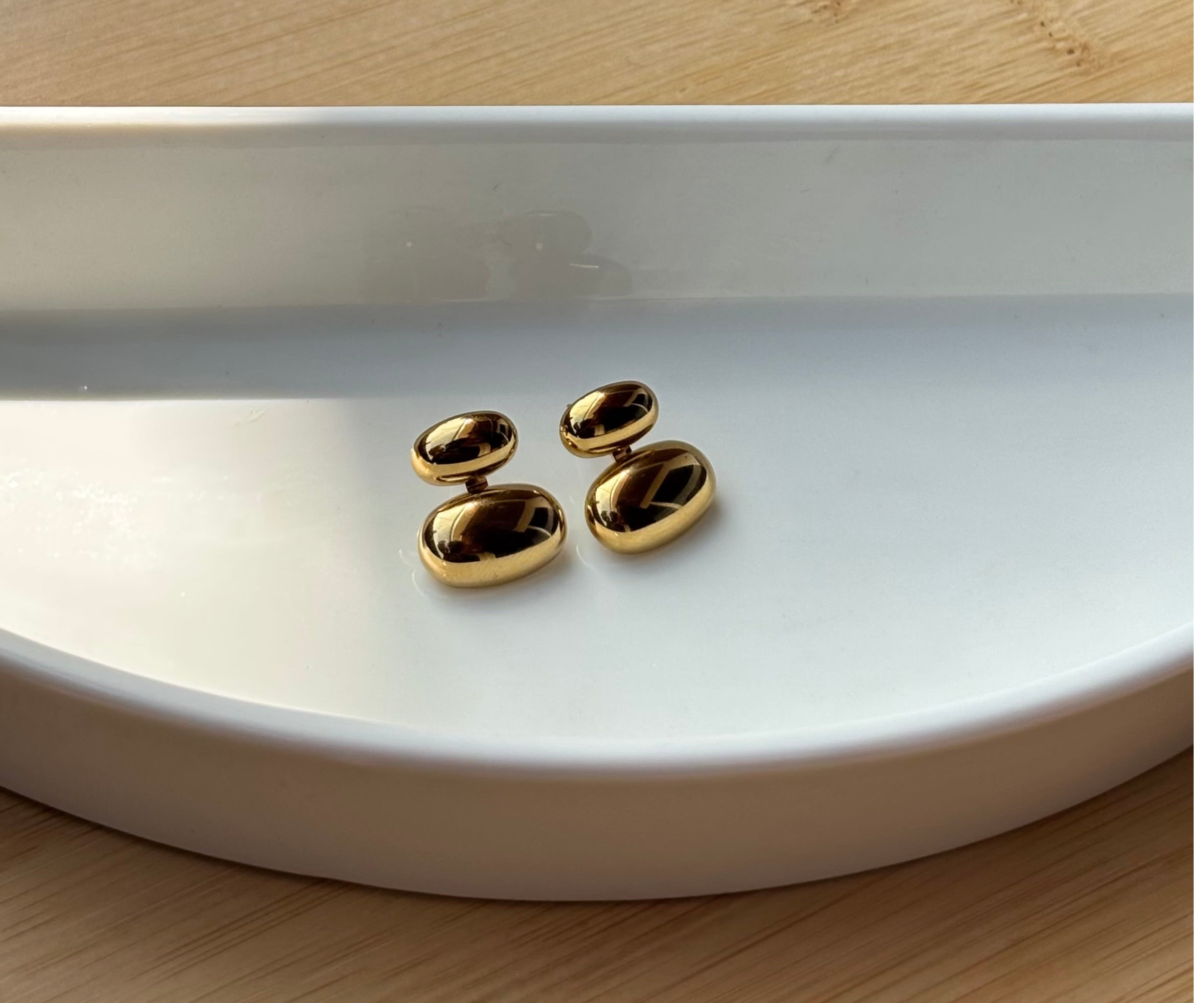 Gold-plated pebble stud earrings shown styled �? multipurpose 2-way studs for versatile everyday looks.