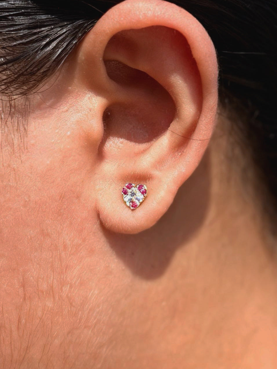 Close-up of colourful heart ball-back stud earrings �? 18k gold-plated playful heart studs for casual wear.