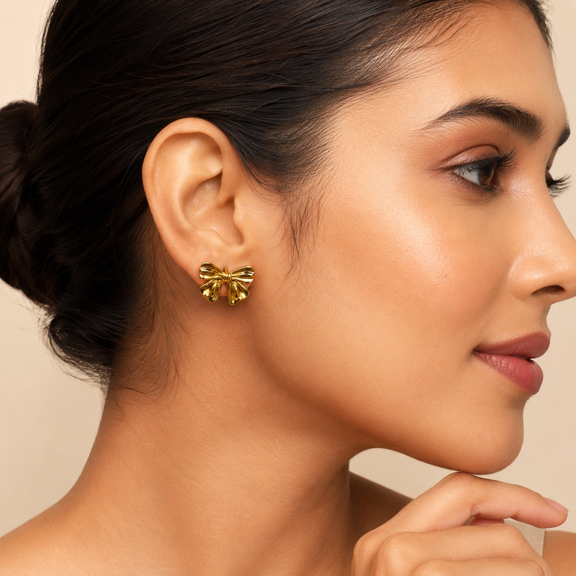 Gold plated bow stud earrings with polished finish