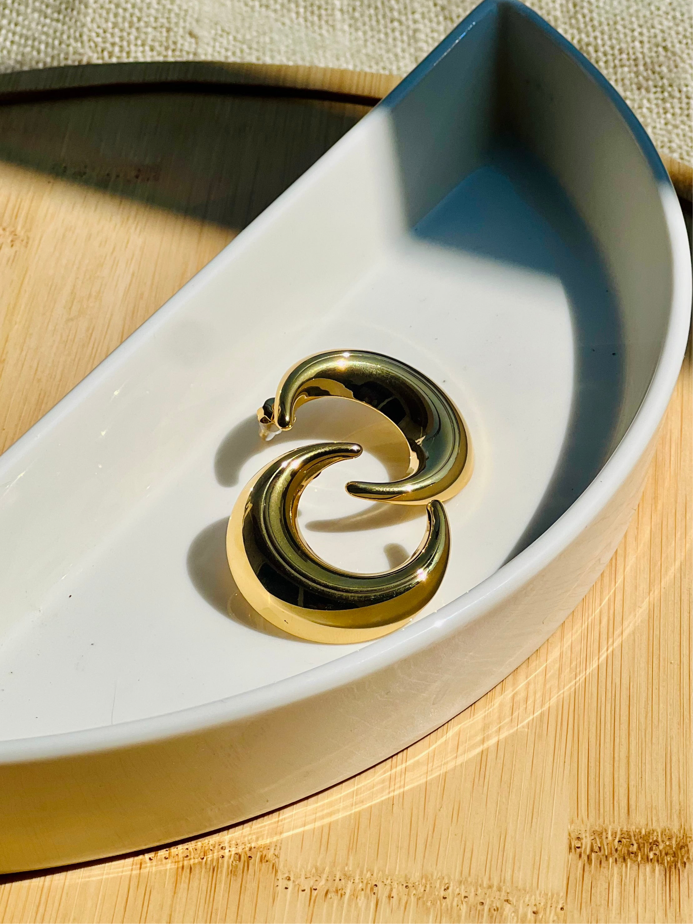Moon studs styled flat �? 18k gold-plated celestial moon hoops for casual and gifting.