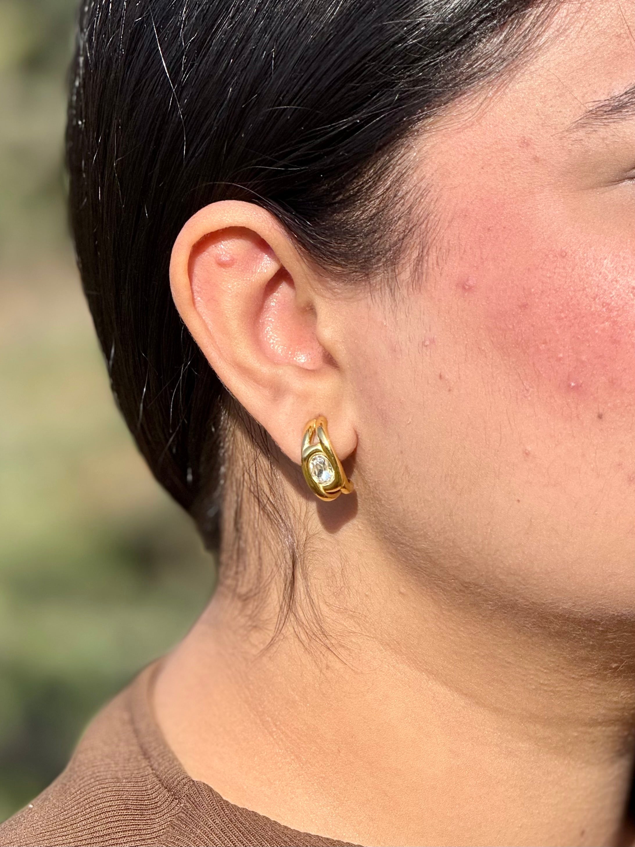 Close-up of Halo oval crystal stud earrings �? 18k gold-plated royal halo studs for statement evening wear.