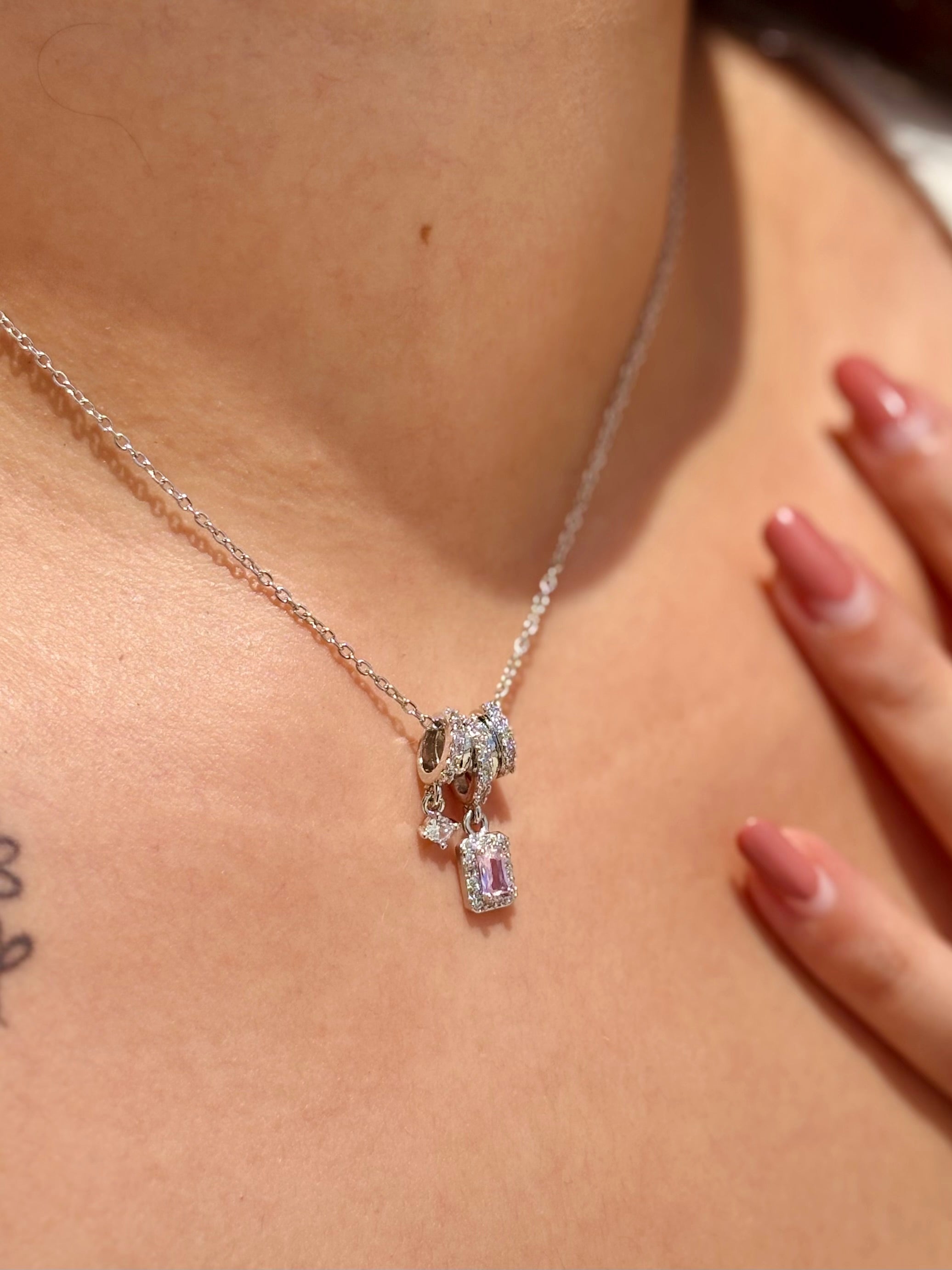 Close-up of pastel stone charm chain necklace in silver finish �? delicate, elegant pendant for everyday wear.