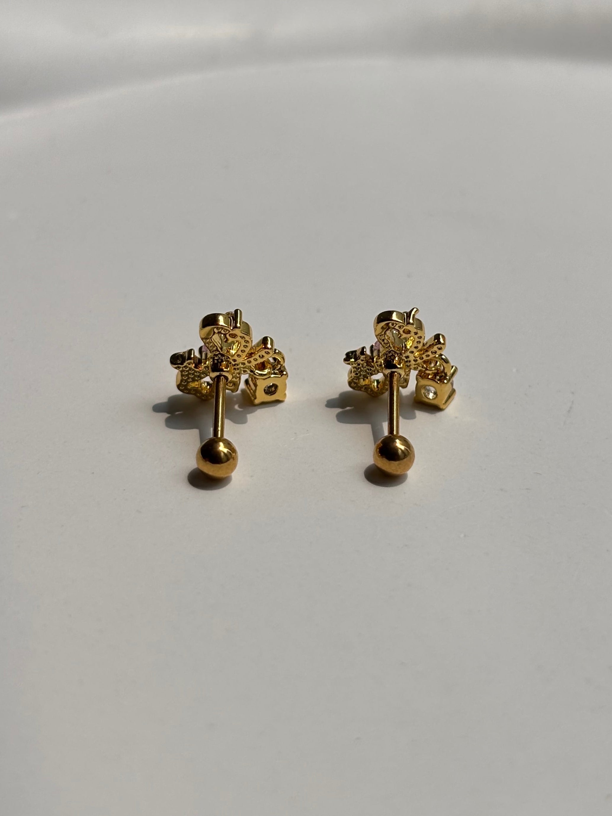 Close-up of 18k gold-plated bow ball-back studs �? sleep-friendly, lightweight design for everyday styling.