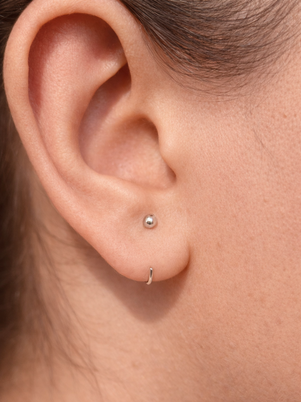 Pair of sterling silver ball hoop earrings �? minimalist poke-free hoops, safe for kids and sensitive skin.