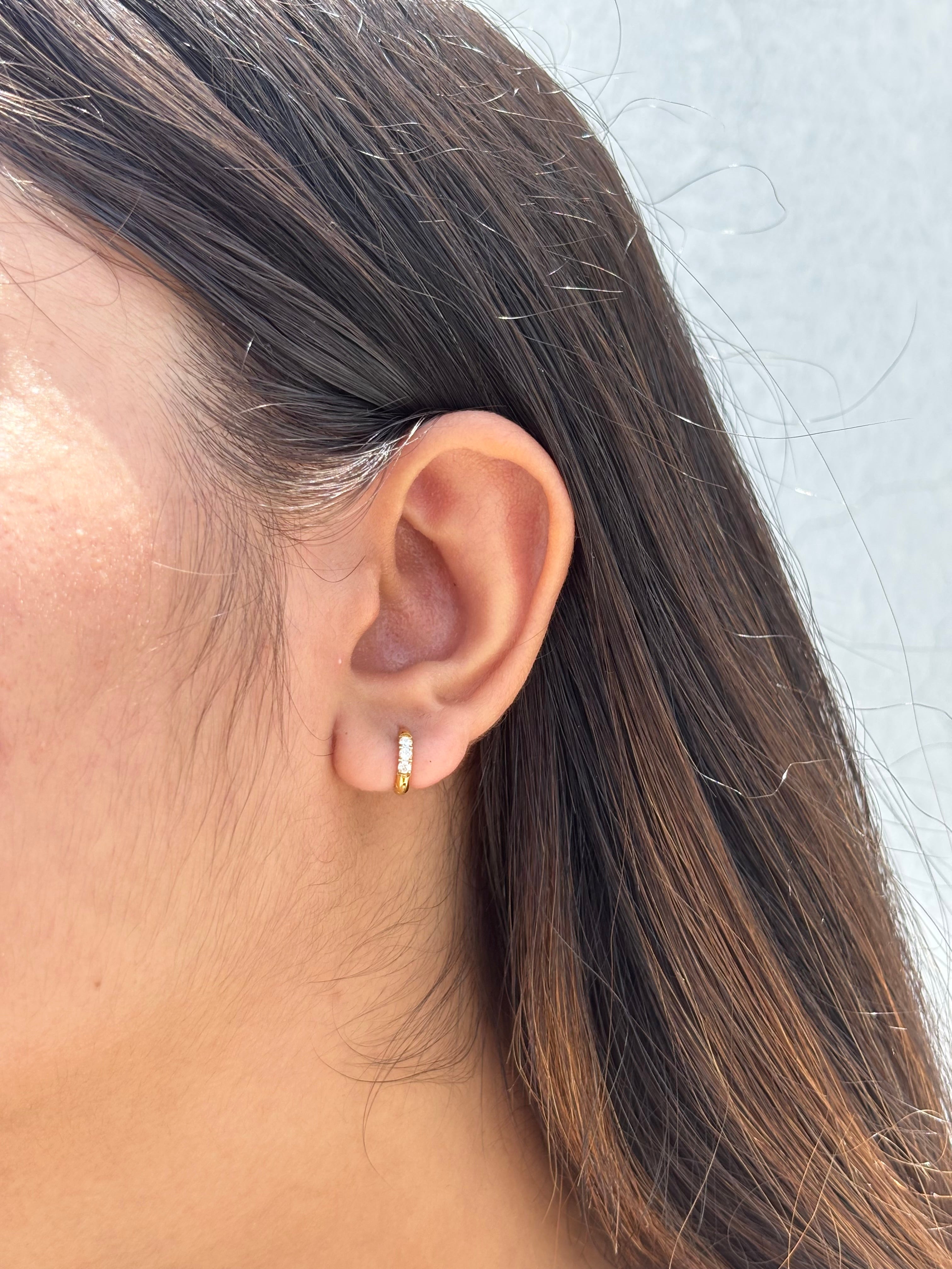 Close-up of gold-plated stone hoops �? hypoallergenic, lightweight dainty hoops for everyday second piercings.