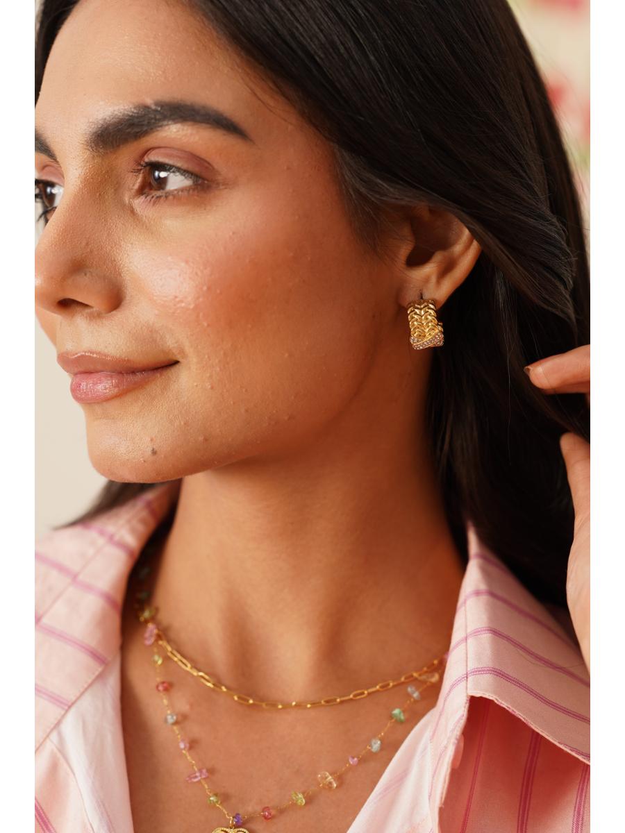 Detail shot of Vaira double-layer necklace �? rainbow stones and heart charm on 18k gold-plated stainless steel.