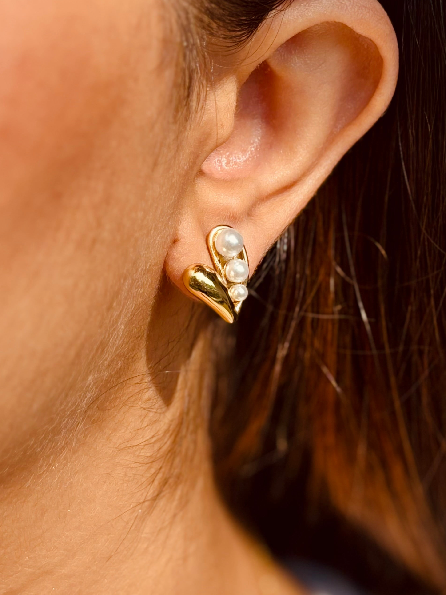 Close-up of heart pearl studs �? 18k gold-plated delicate minimal heart pearl earrings for casual wear.