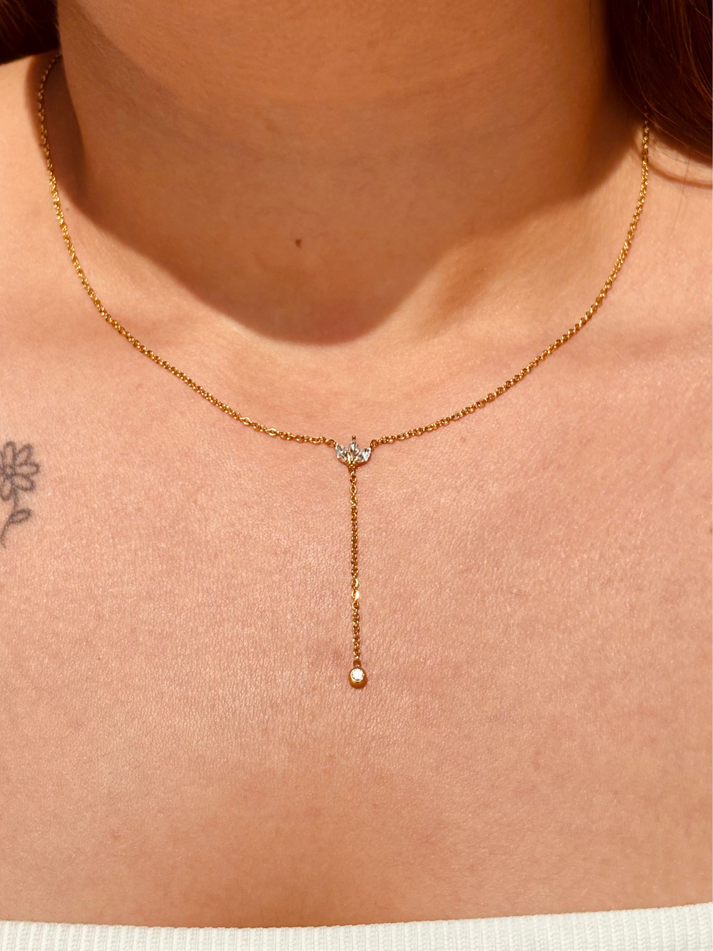 Stella lariat gold-plated necklace styled flat �? delicate leaf and ball drop chain for festive and gifting wear.
