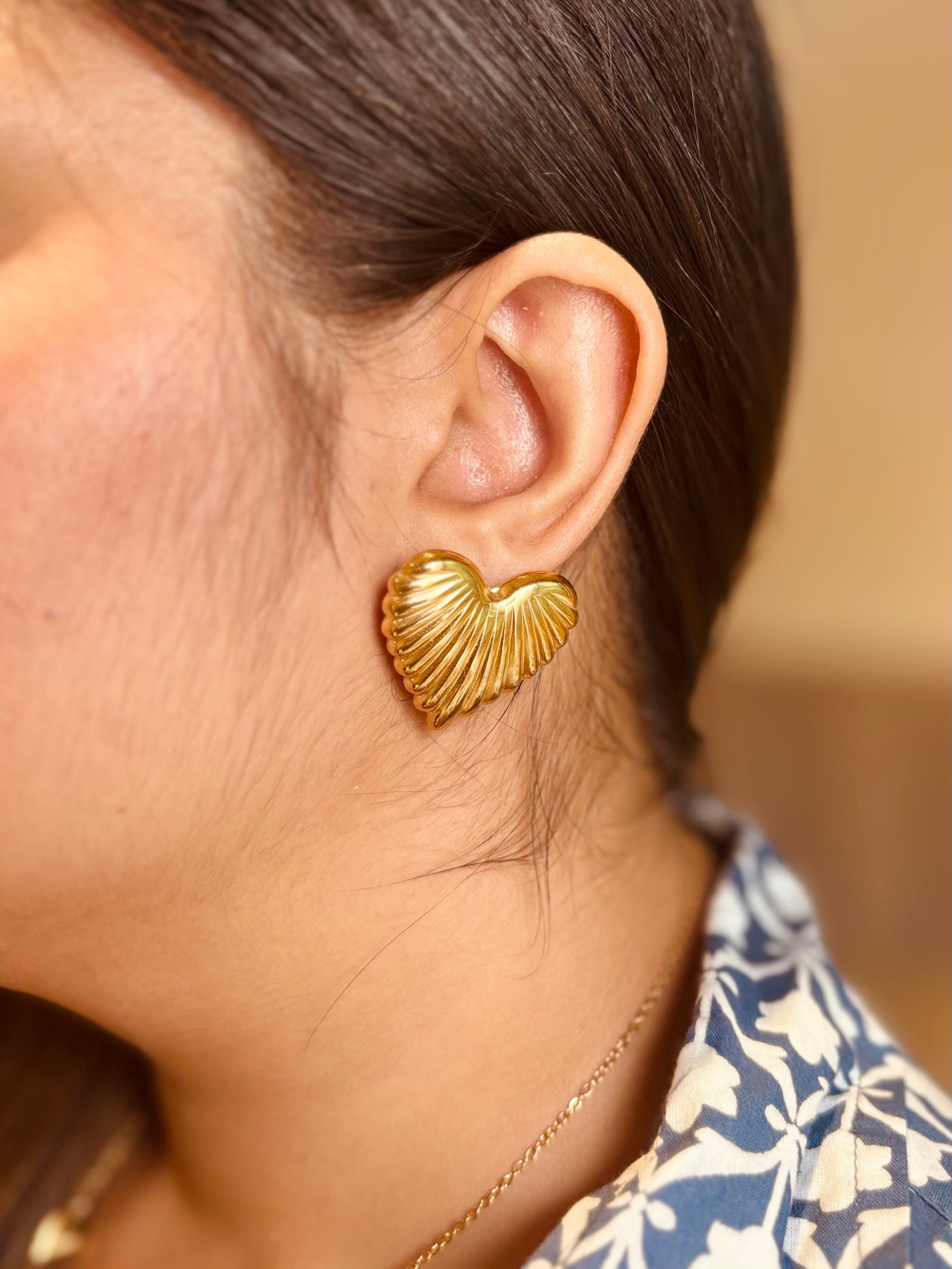 Close-up of heart stud earrings �? 18k gold-plated sweet minimal heart studs for casual wear.