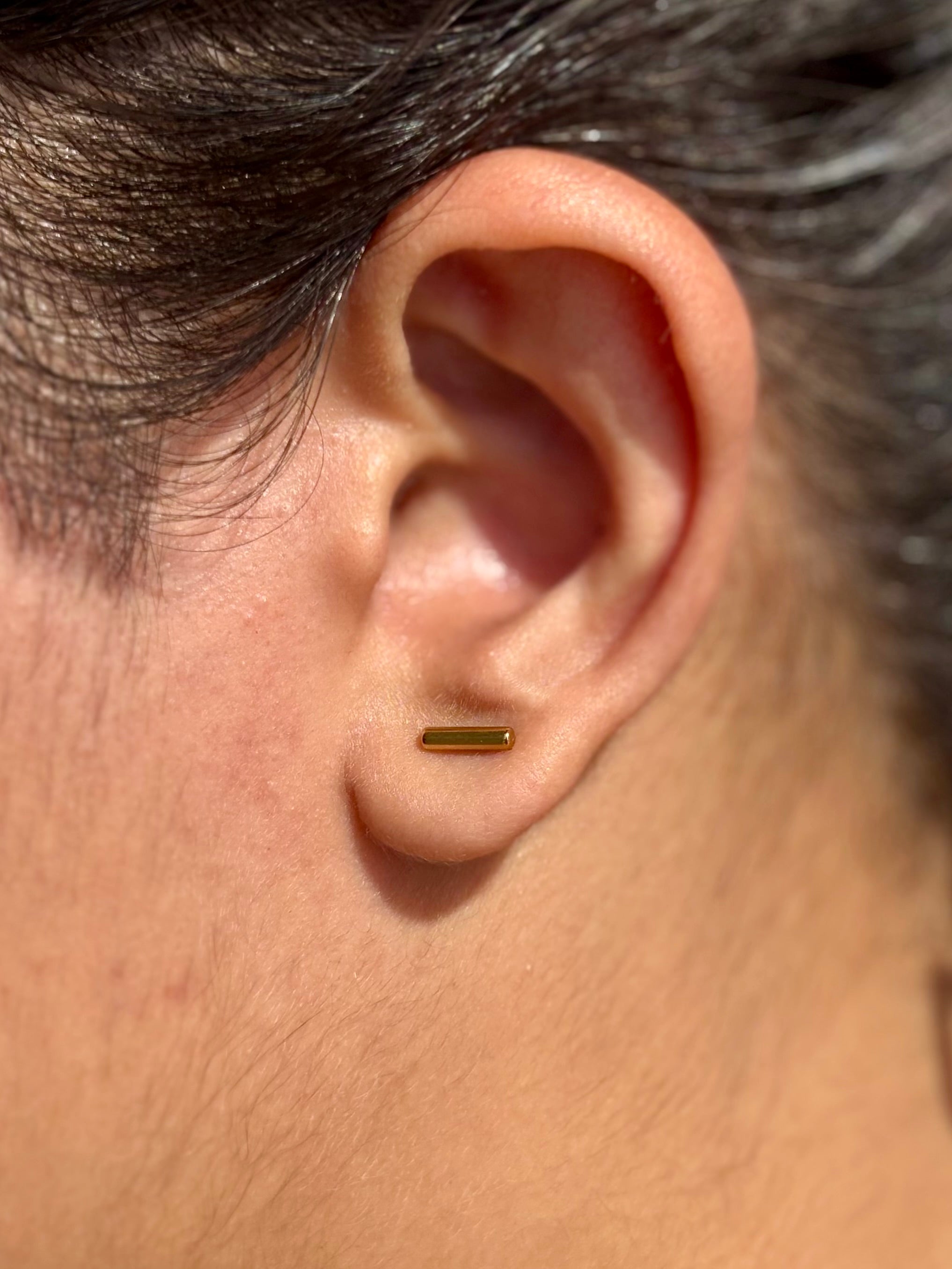 Pair of 18k gold-plated line studs �? sleek minimal bar earrings for layered ear styling and evening looks.