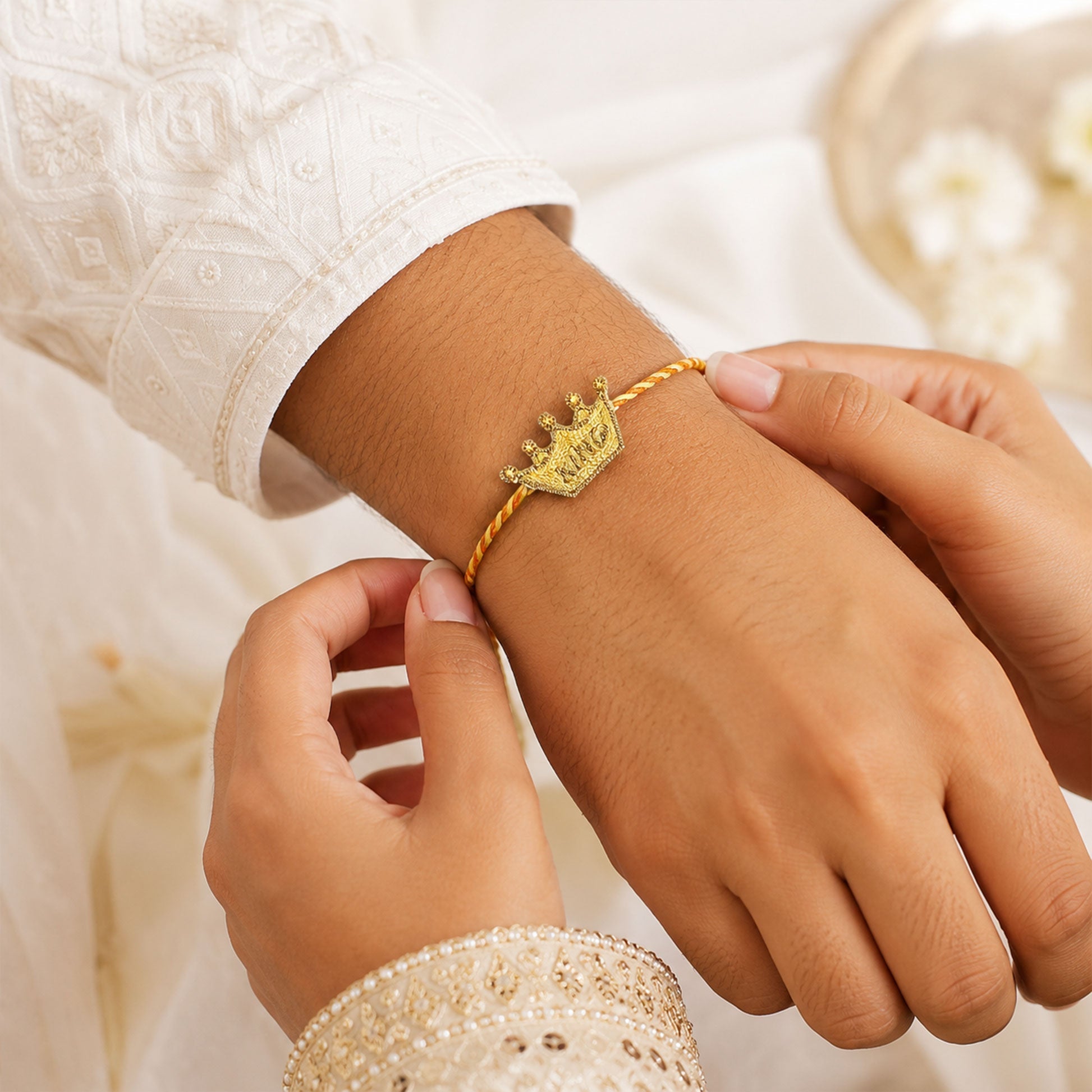 Yellow and orange braided thread rakhi with crown centerpiece