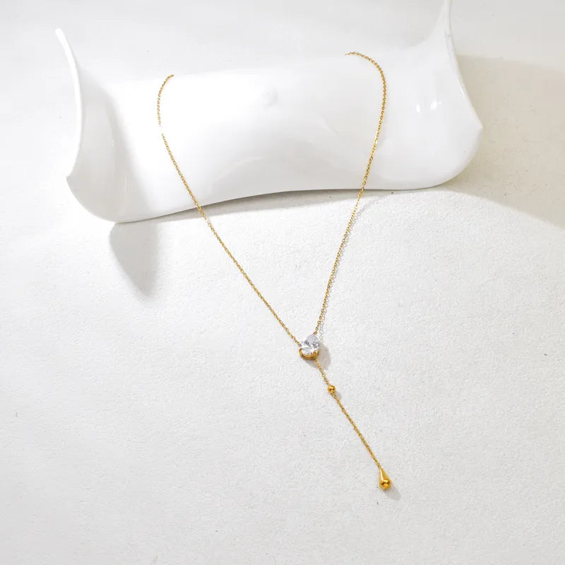Close-up of stone lariat necklace �? 18k gold-plated deep-neckline lariat for evening styling.