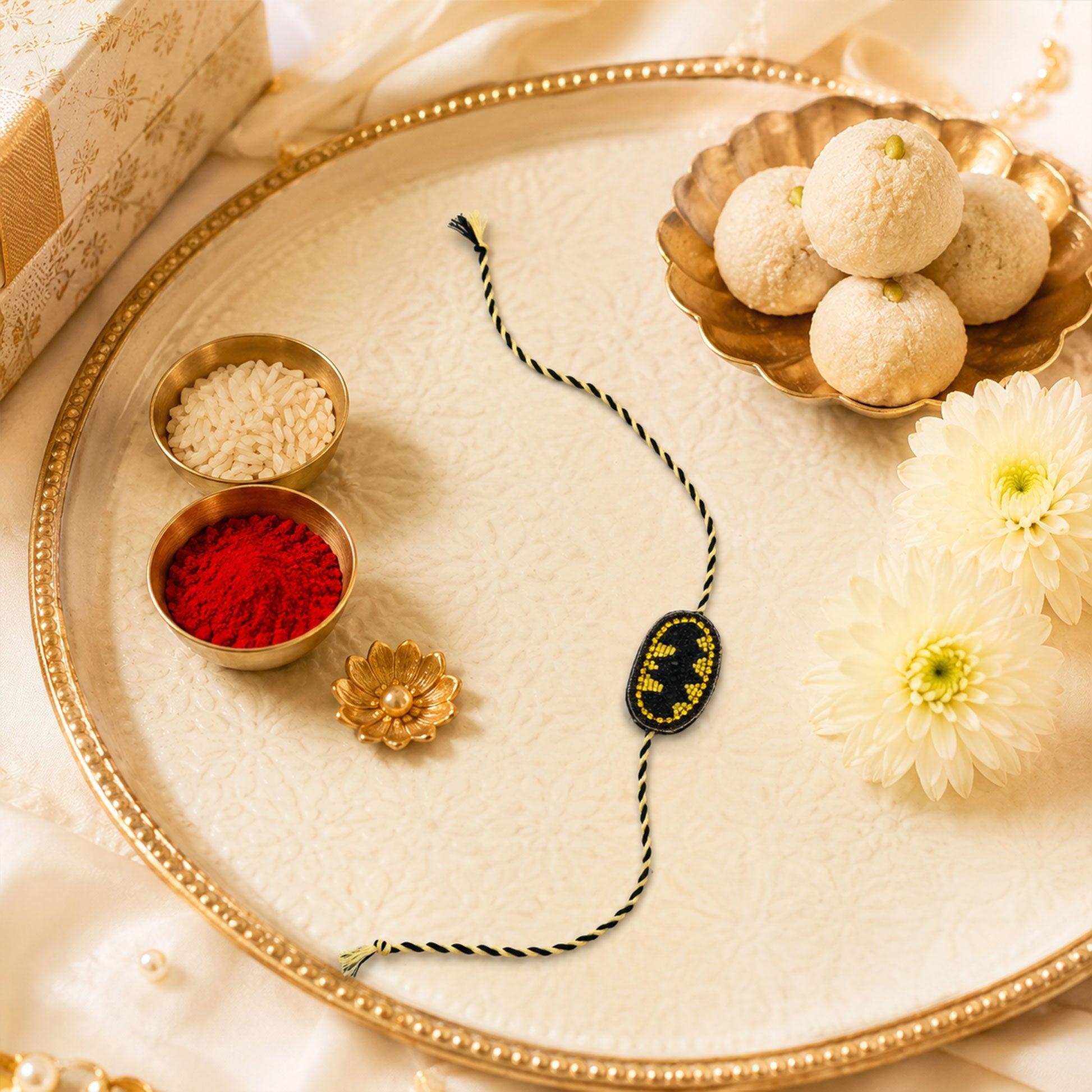 Braided thread rakhi with superhero bat symbol centerpiece