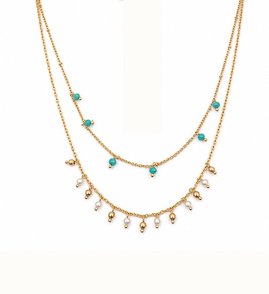 Gold layered turquoise and pearl beaded necklace on white background