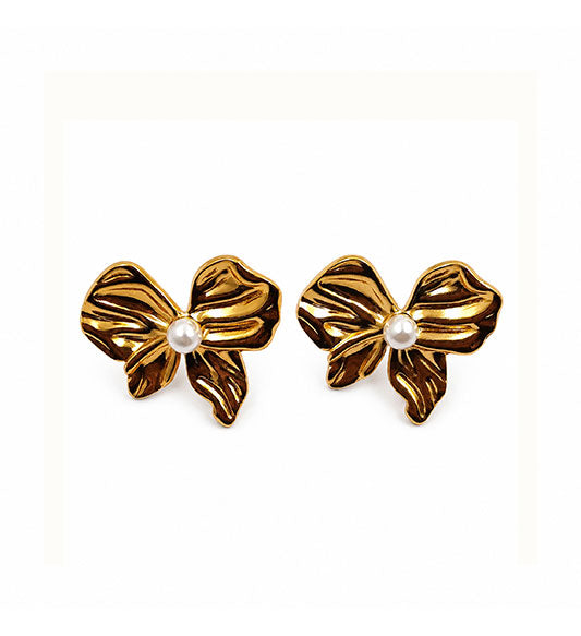 Gold pearl bow stud earrings pair on white background