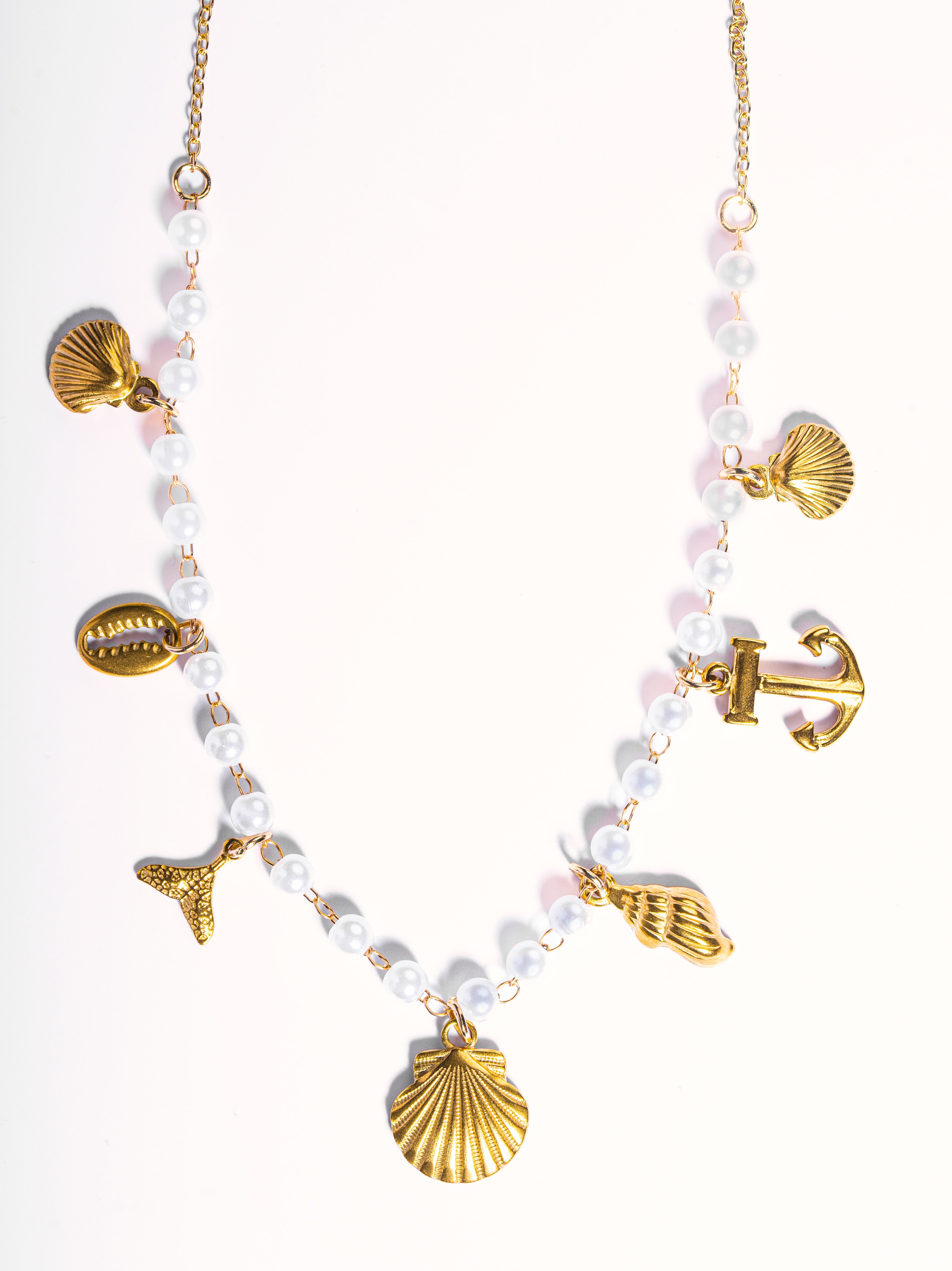 Styled view of Cresta drop earrings �? 18k gold-plated marine-charm pearl drops for casual and gifting.